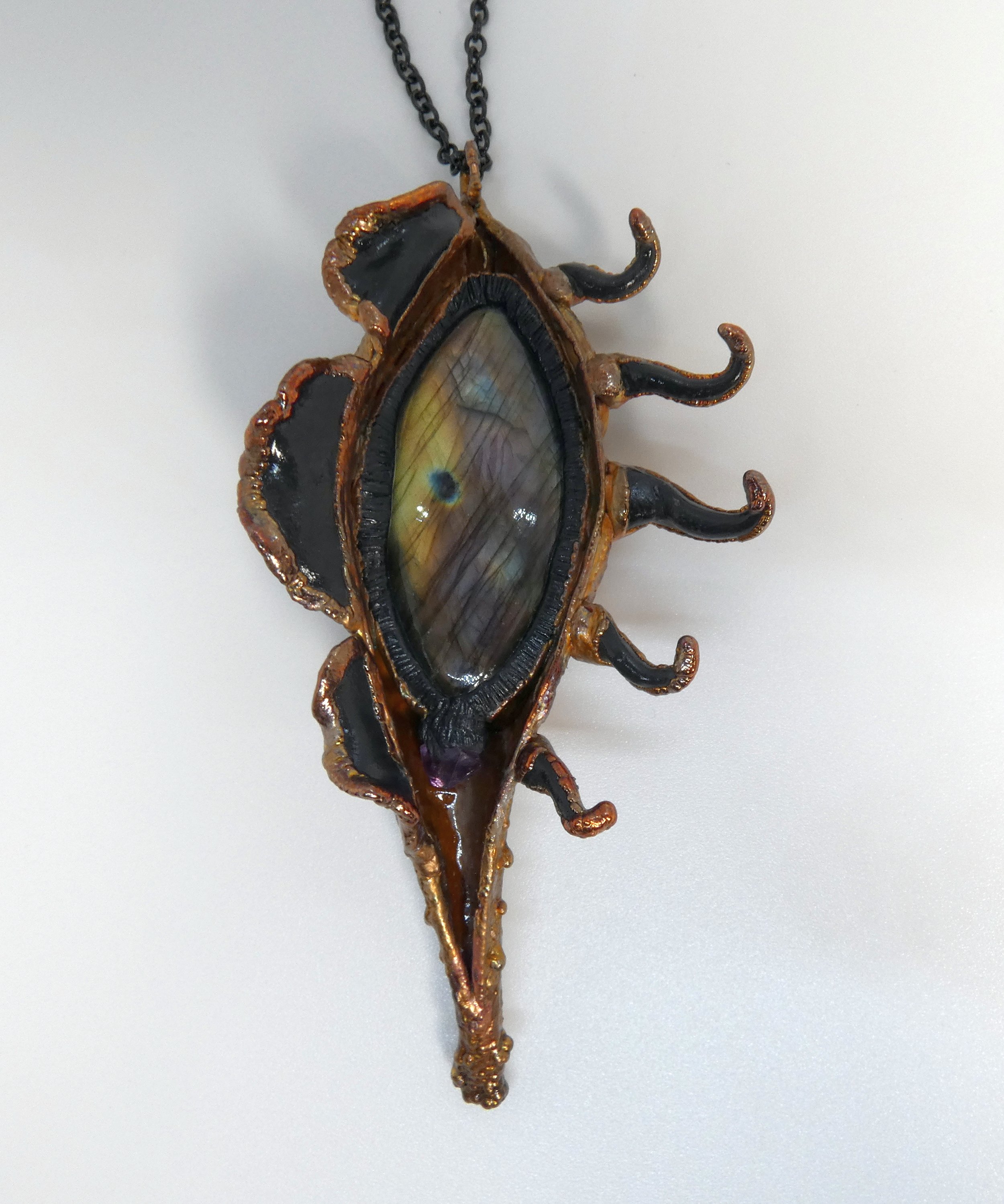 Symbiont 019 (Pendant): milkweed pod, labradorite, amethyst point, epoxy clay, electroformed in copper. 5” H x 2.5” W. Available $350.