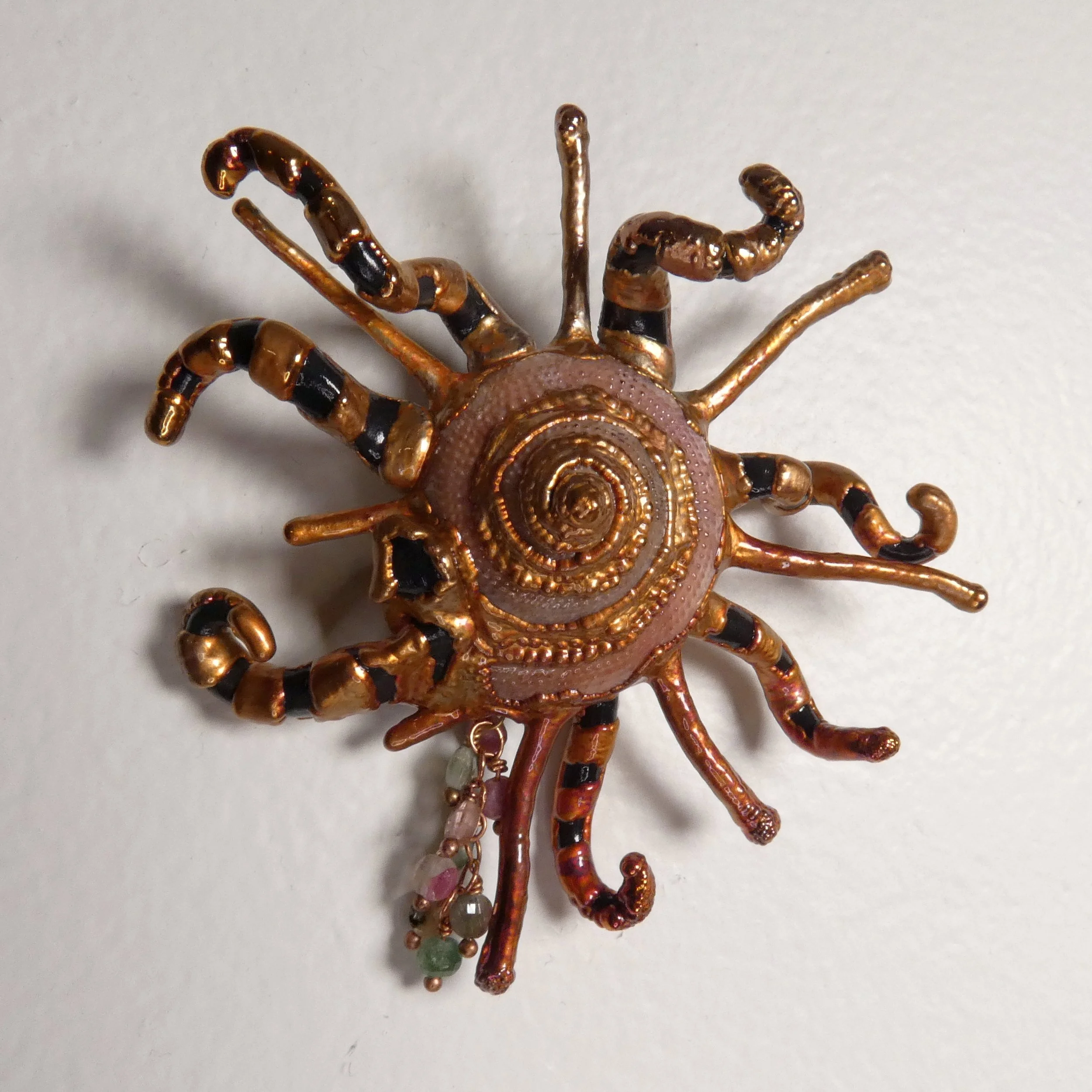 Symbiont 031 (Wall sculpture with keyhole slot): seashell (Guildfordia yoka), epoxy clay, electroformed in copper, with faceted tourmaline beads. 3” H x 3” W x 1” D. Available $350.