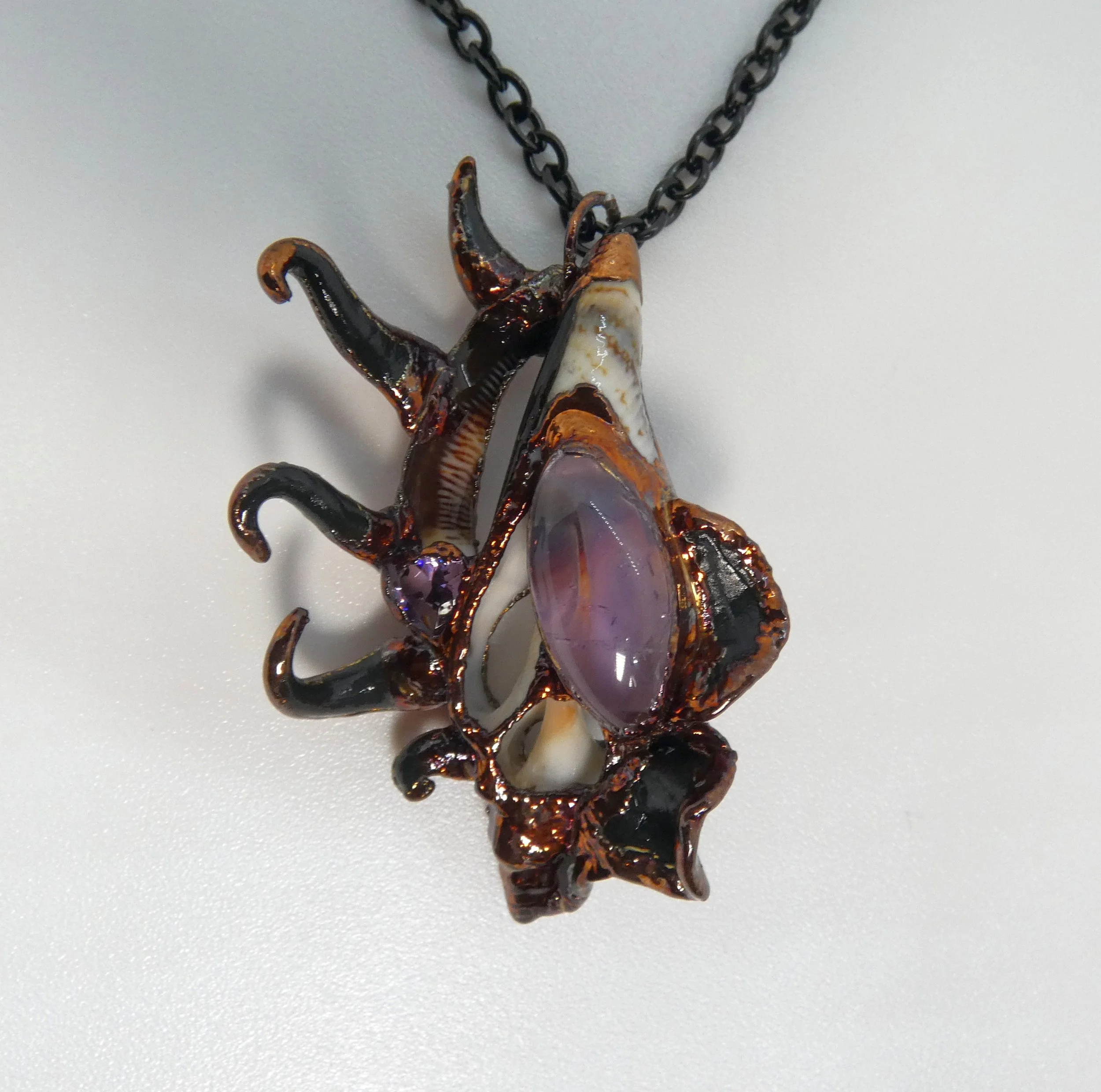 Symbiont 043 (Pendant): seashell slice, amethyst, rhinestone, epoxy clay, electroformed copper. 2" H x 1.5" W. Available $125.