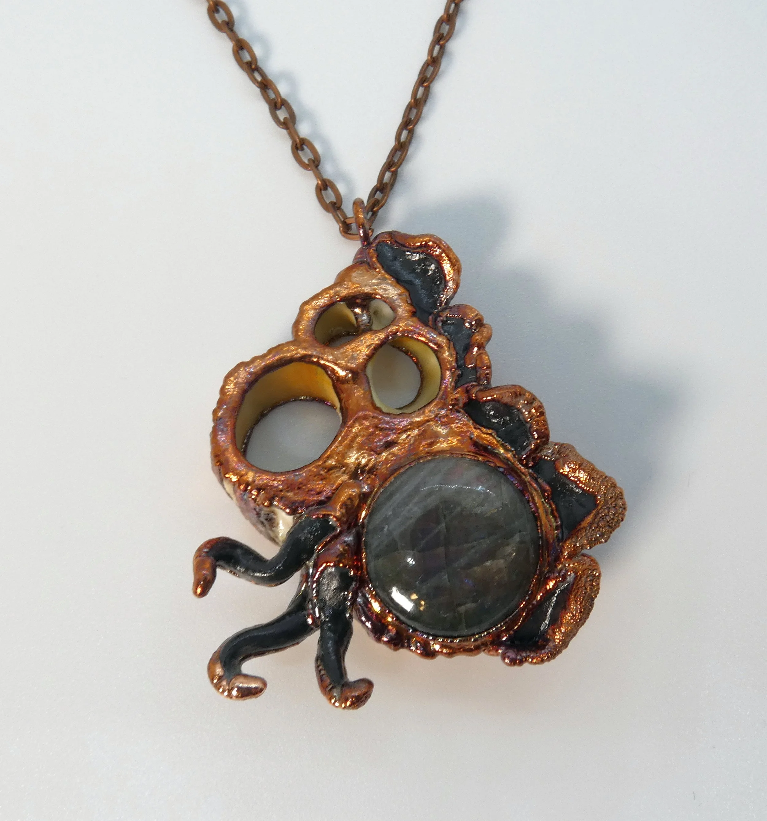 Symbiont 010 (Pendant): seashell slice, purple labradorite, epoxy clay, electroformed in copper. 3” H x 2.25 W. Available $200.