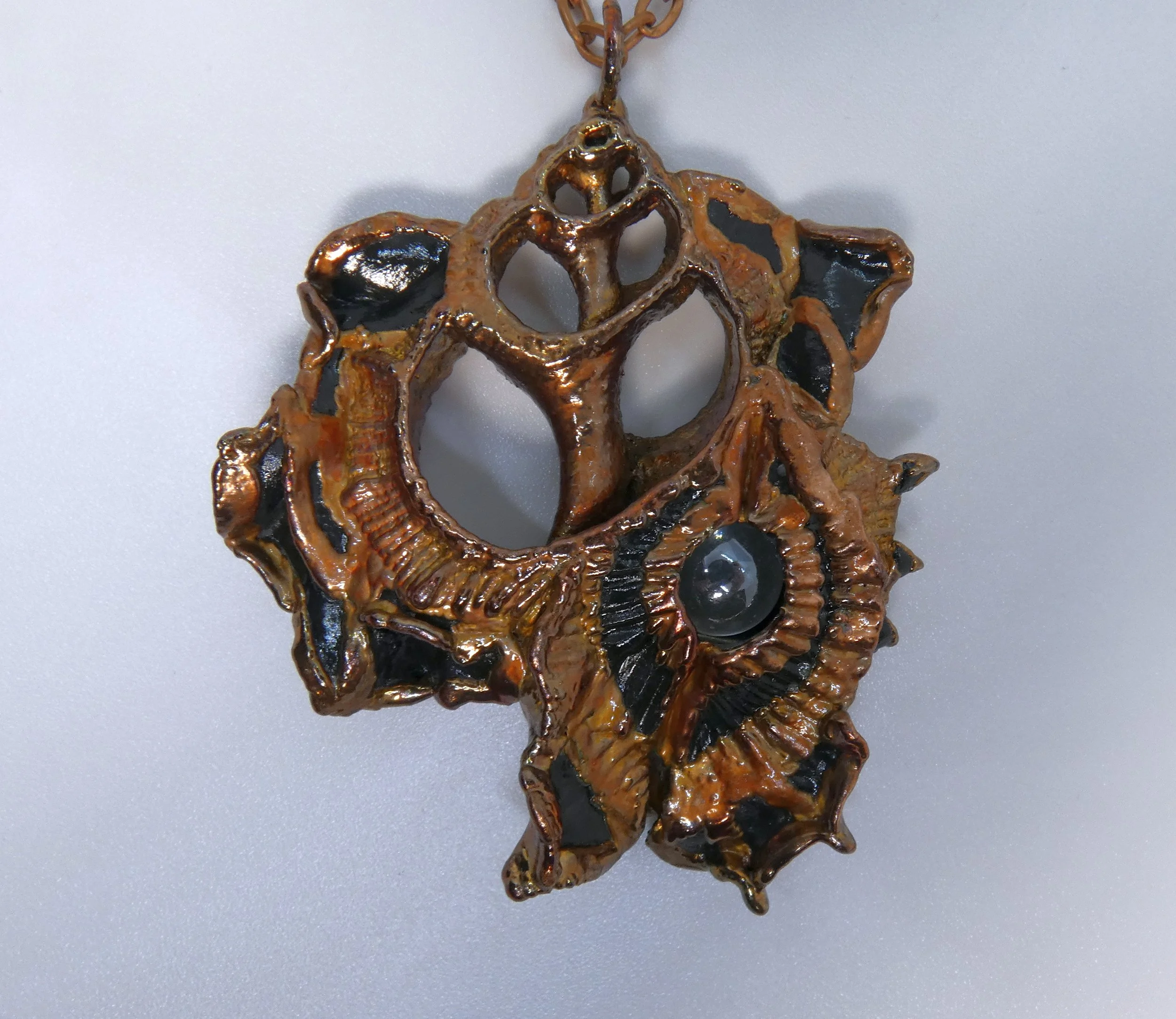 Symbiont 005 (Pendant): seashell slice, moving glass marble, epoxy clay, electroformed in copper. 3” H x 2.5” W. Available $350
