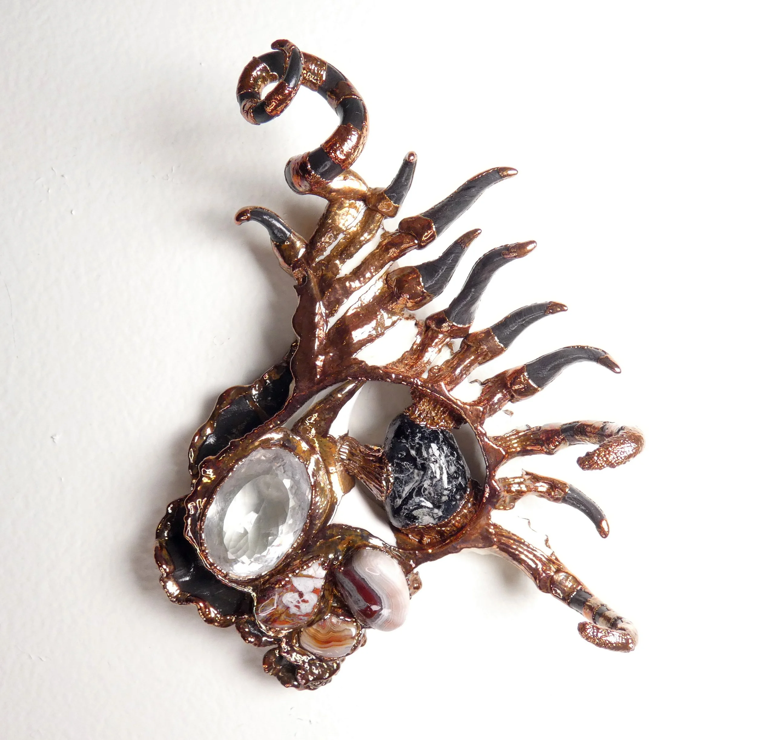 Symbiont 046 (Wall sculpture): seashell slice, faceted quartz, Apache Tear obsidian, crazy lace agate, epoxy clay, electroformed copper. 6" H x 5" W x 2” D. In private collection.