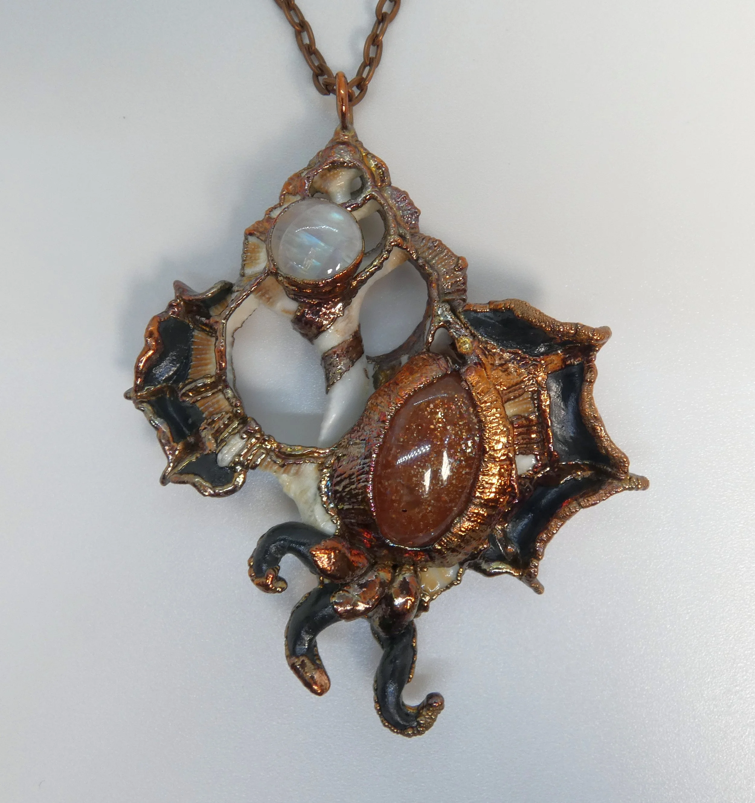 Symbiont 011 (Pendant): seashell slice, sunstone, moonstone, epoxy clay, electroformed in copper. 4” H x 3” W. Available $400.