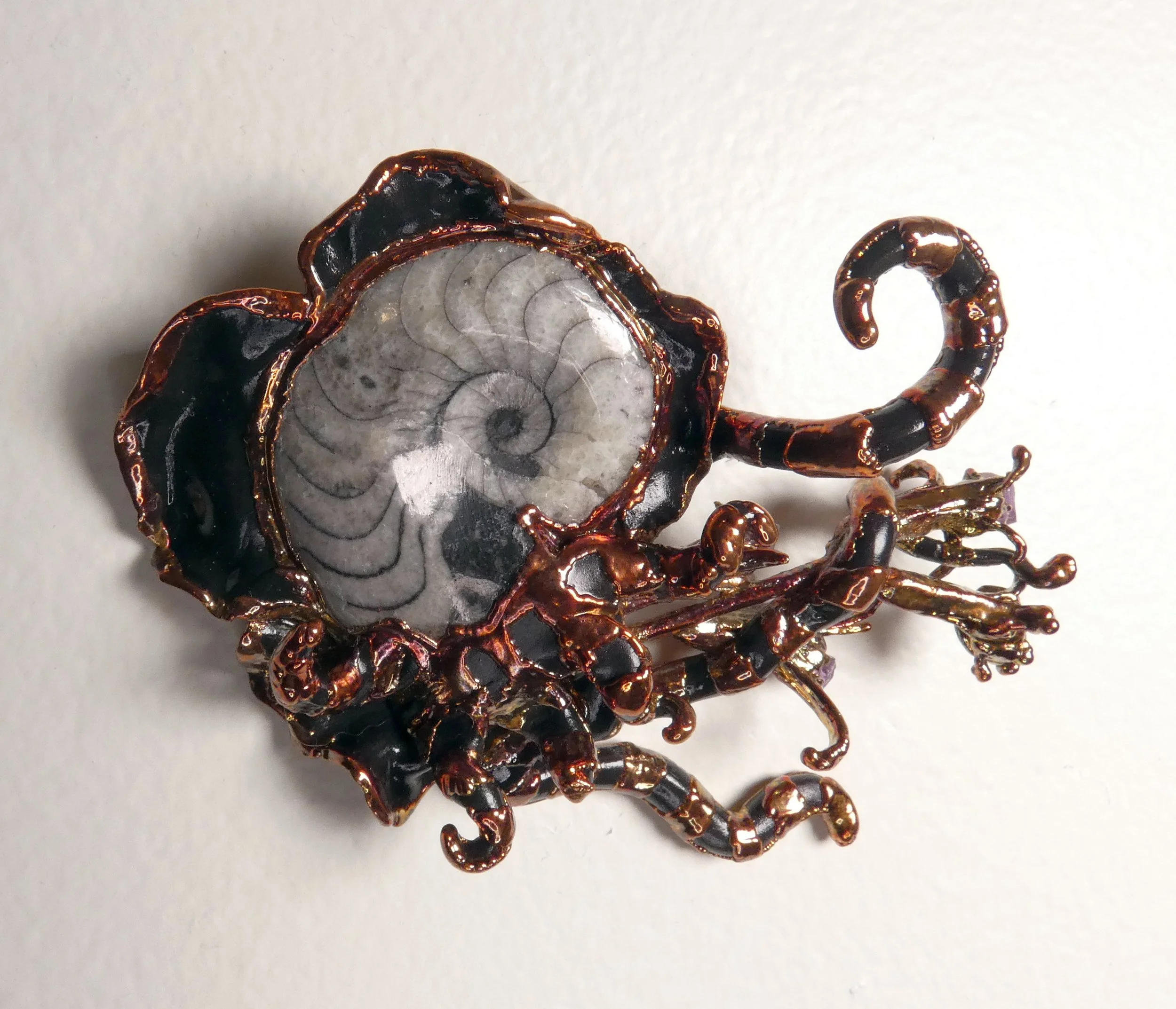 Symbiont 030 (Wall sculpture with keyhole slot): Orthoceras fossil, dried flower stems, amethyst crystals, epoxy clay, electroformed in copper. 3.5” H x 4” W x 2” D. Available $750.