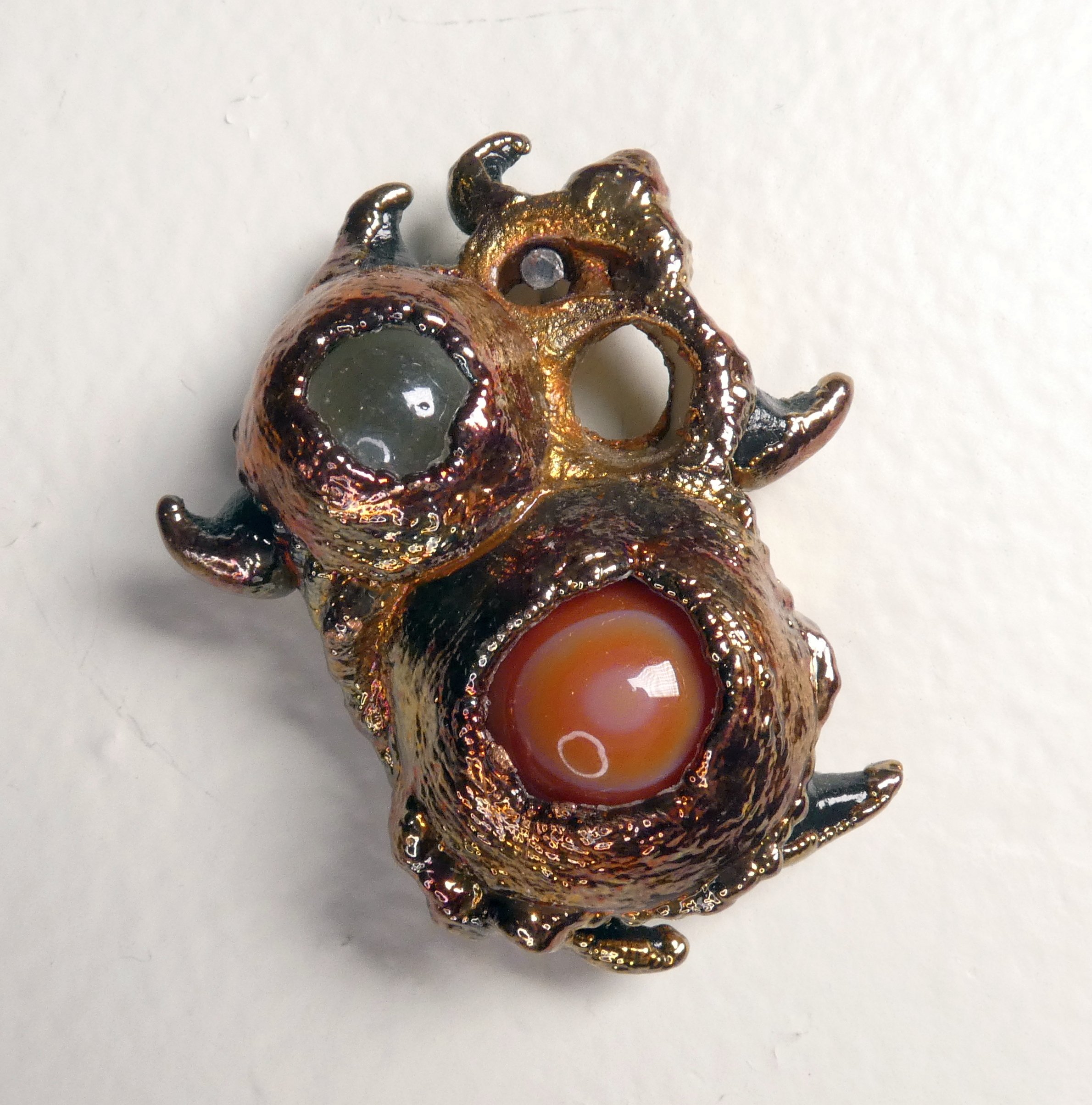 Symbiont 035 (Fidget Toy): seashell slice, moving glass and sardonyx marbles, epoxy clay, electroformed in copper. 2” H x 2” W. In private collection.