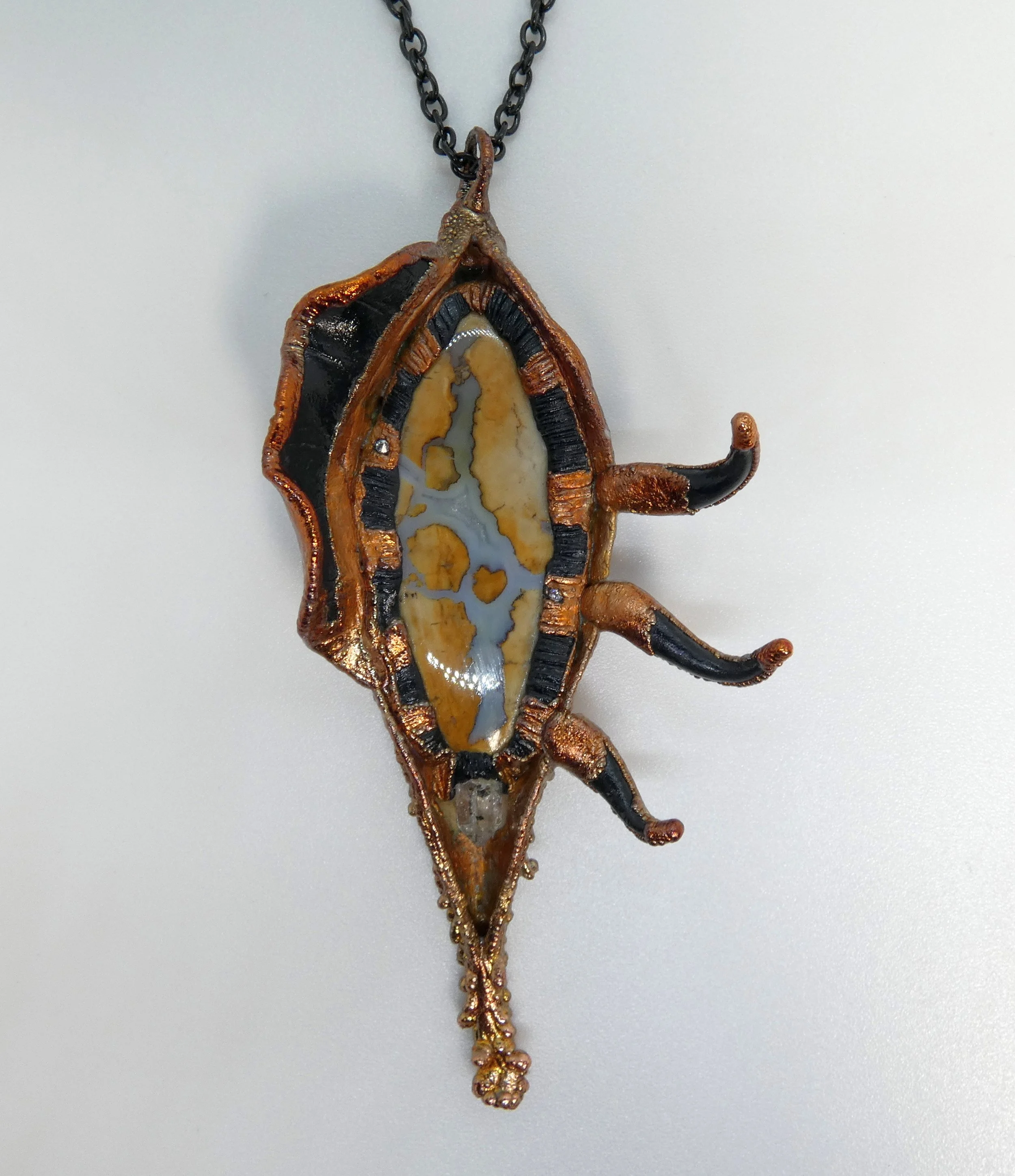 Symbiont 020 (Pendant): milkweed pod, Ohio flint, Herkimer diamond quartz, rhinestones, epoxy clay, electroformed in copper. 5” H x 2.5” W. Available $350.