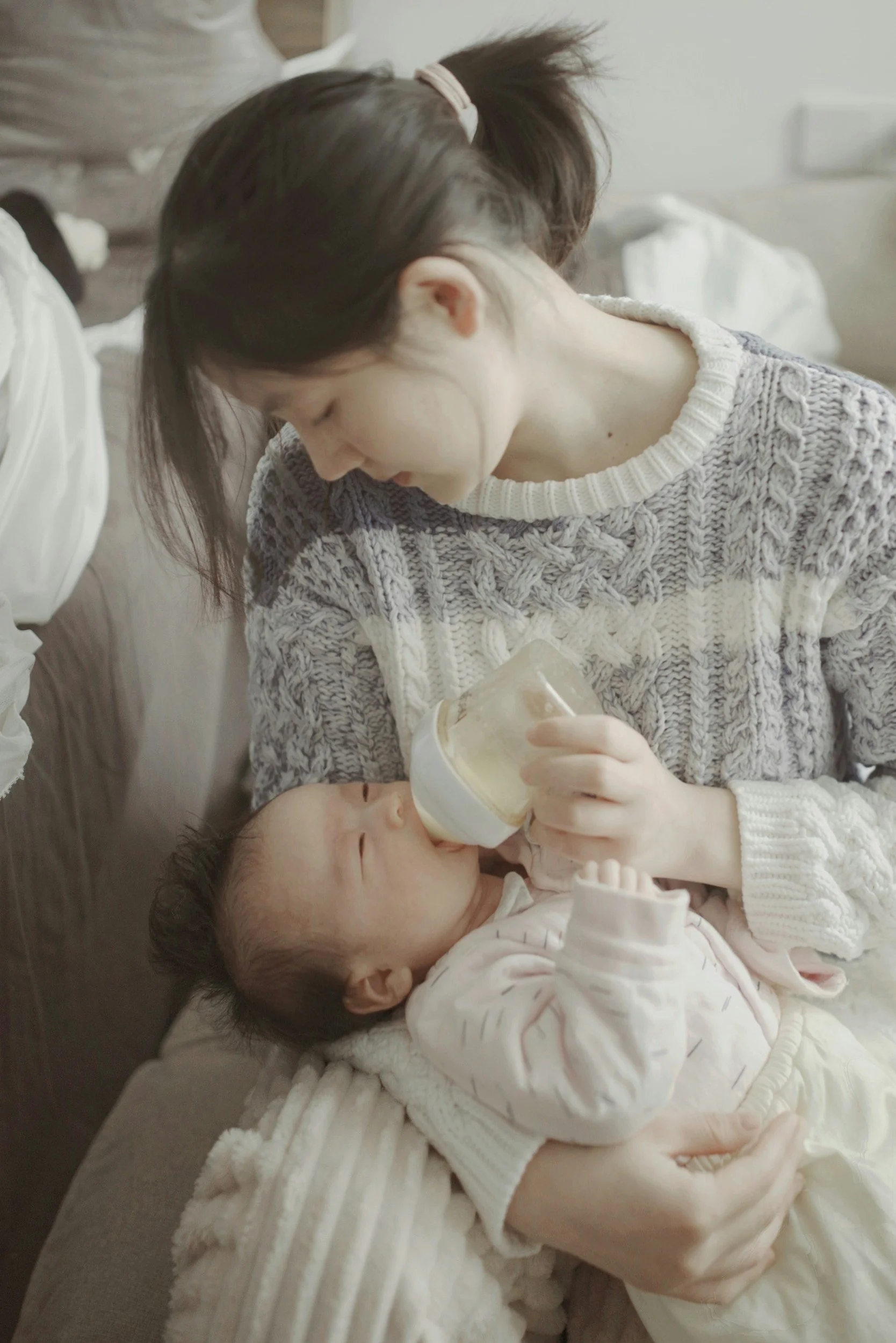 Mother bottle feeding her newborn while healing from breastfeeding guilt