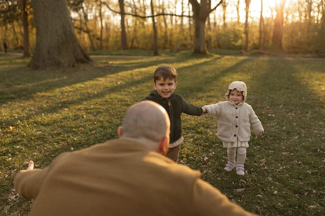 vårfamiljefotografering två barn springer mot pappa2.jpg