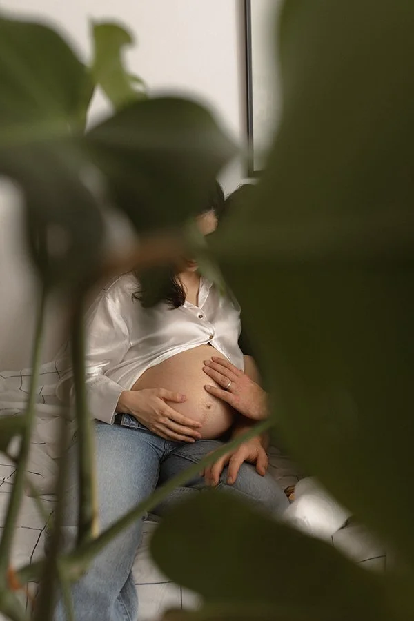 Pregnant woman with her partner and daughter during an in-home maternity photoshoot in Lund