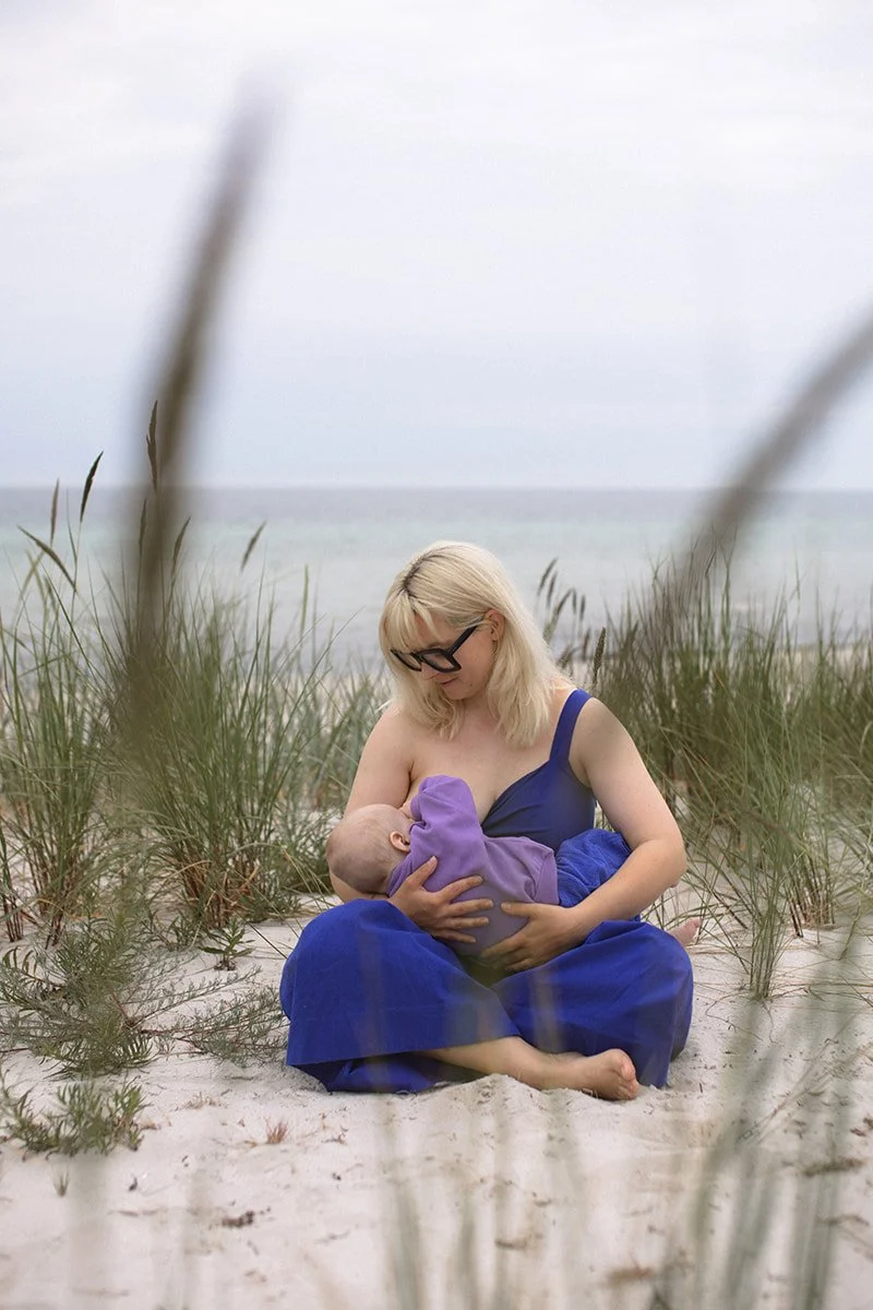 Mamma ammar sin bebis på stranden i Falsterbo under en solig morgon i juni.