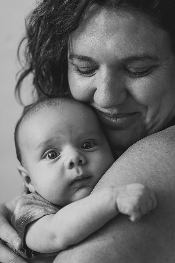 Mother holding her baby during a calm motherhood photography session in Malmö. Natural mother and baby portrait with soft tones, perfect as a meaningful Mors Dag present.
