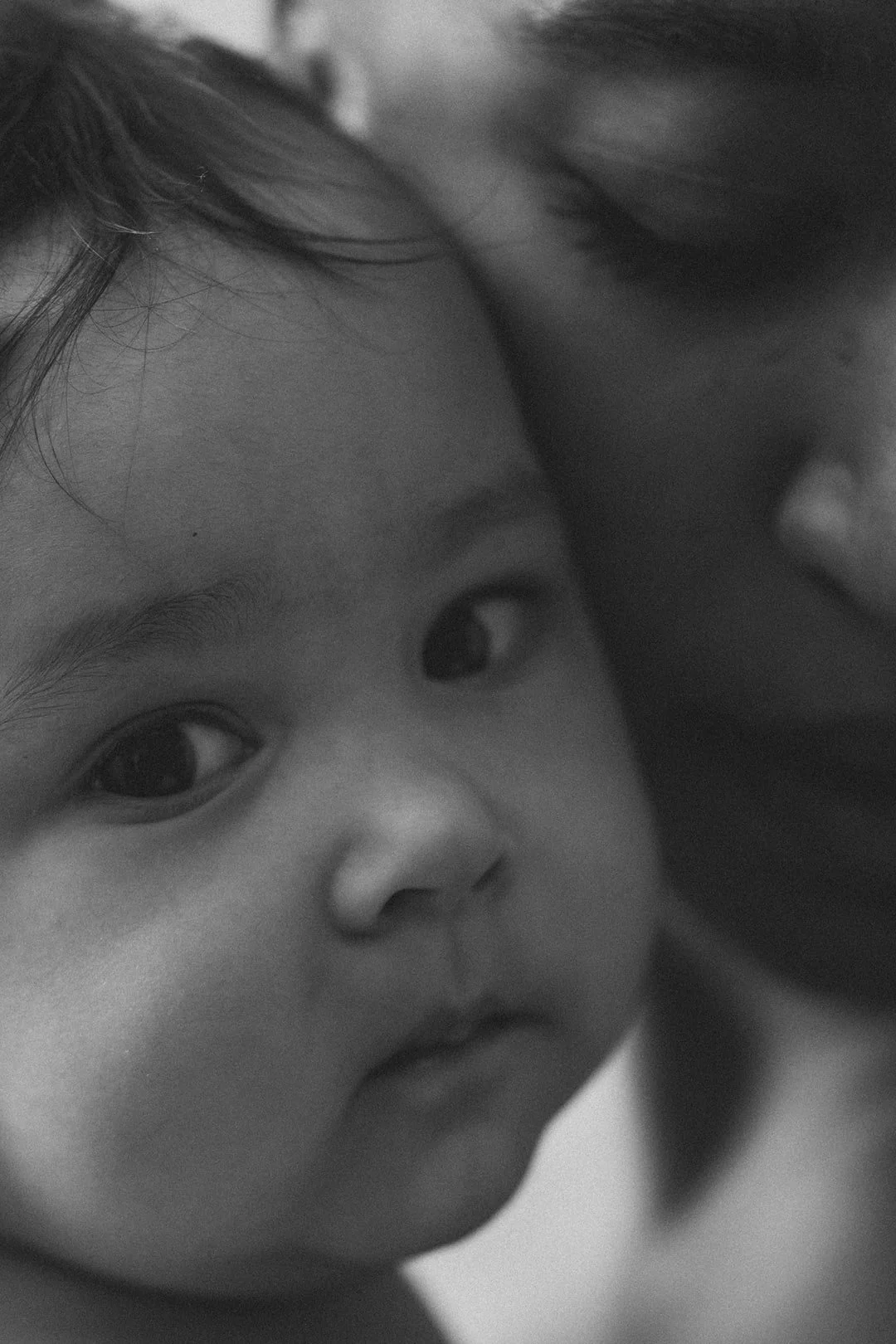 Black and white close-up portrait of a baby with parent during an intimate family photography session in Malmö. Emotional motherhood photography and timeless Mors Dag memory.