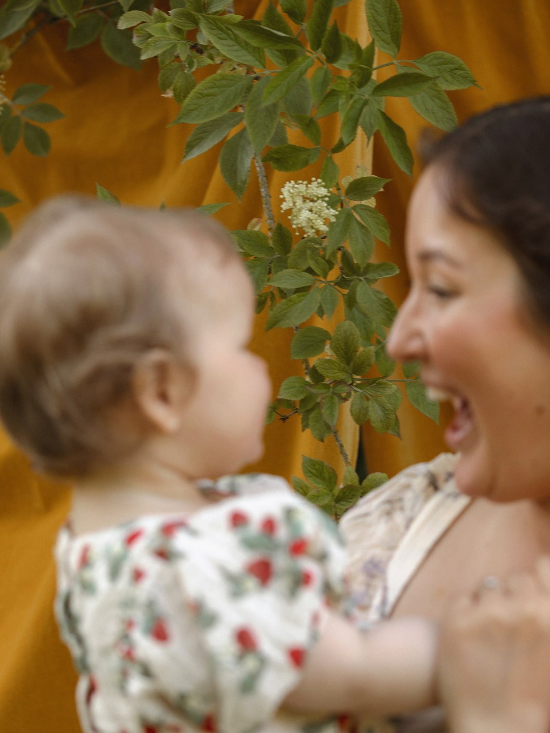 Mamma och bebis i profil med blommande natur i bakgrunden