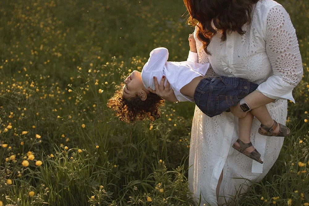 Familjefotografering av en mamma och son som delar en lekfull stund tillsammans i Alnarp, Skåne, fångad i en naturlig utomhusmiljö.