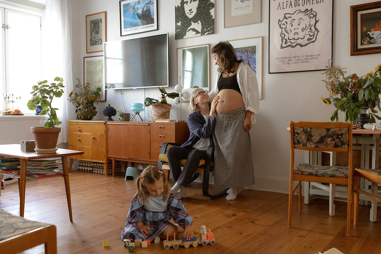 Pregnant woman with her partner and daughter during an in-home maternity photoshoot in Lund