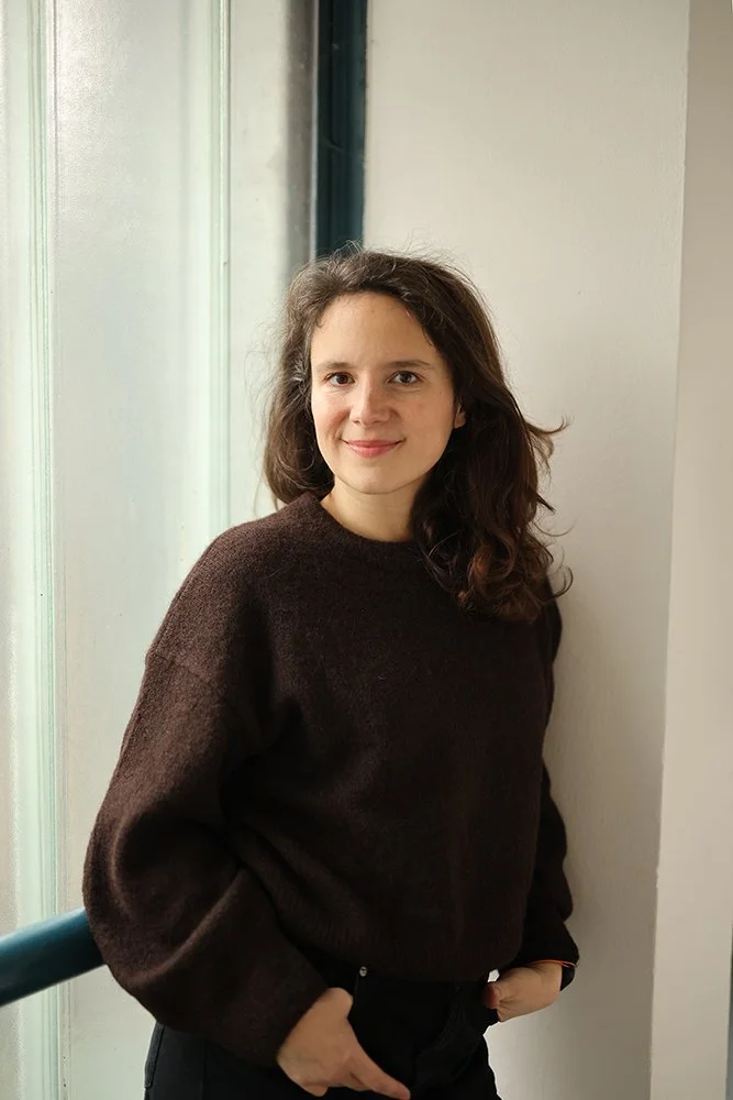 Porträtt av nyföddfotograf i naturligt fönsterljus i Skåne, lugn och närvarande.