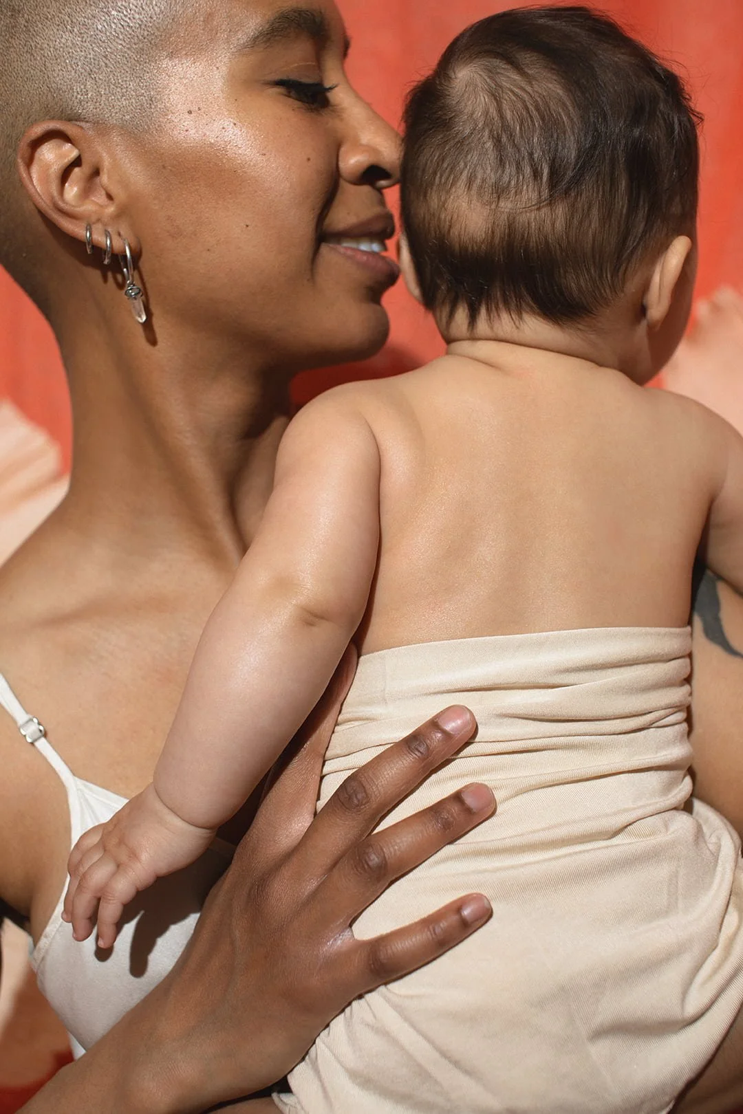 Close-up of mother holding her baby during an intimate motherhood photography session in Malmö. Natural family portrait capturing connection and tenderness for Mors Dag memories.