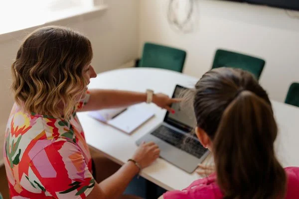 Ness working at a laptop with a client