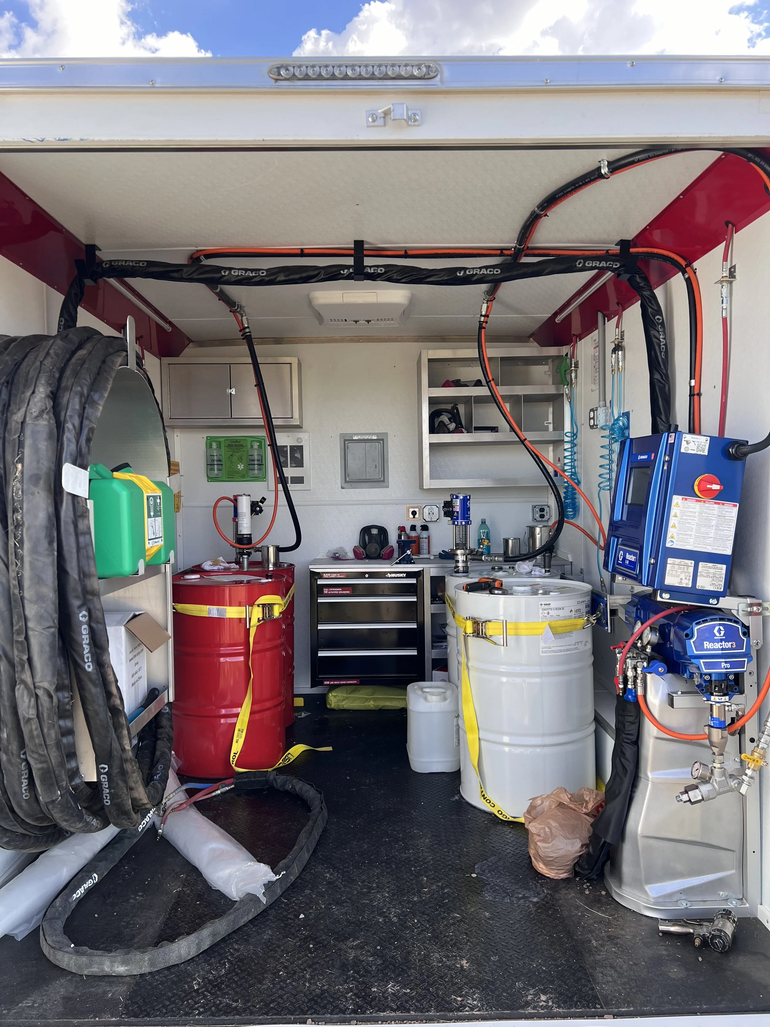 Interior of a mobile science or research lab equipped with tanks, tubing, a control panel, and scientific instruments.