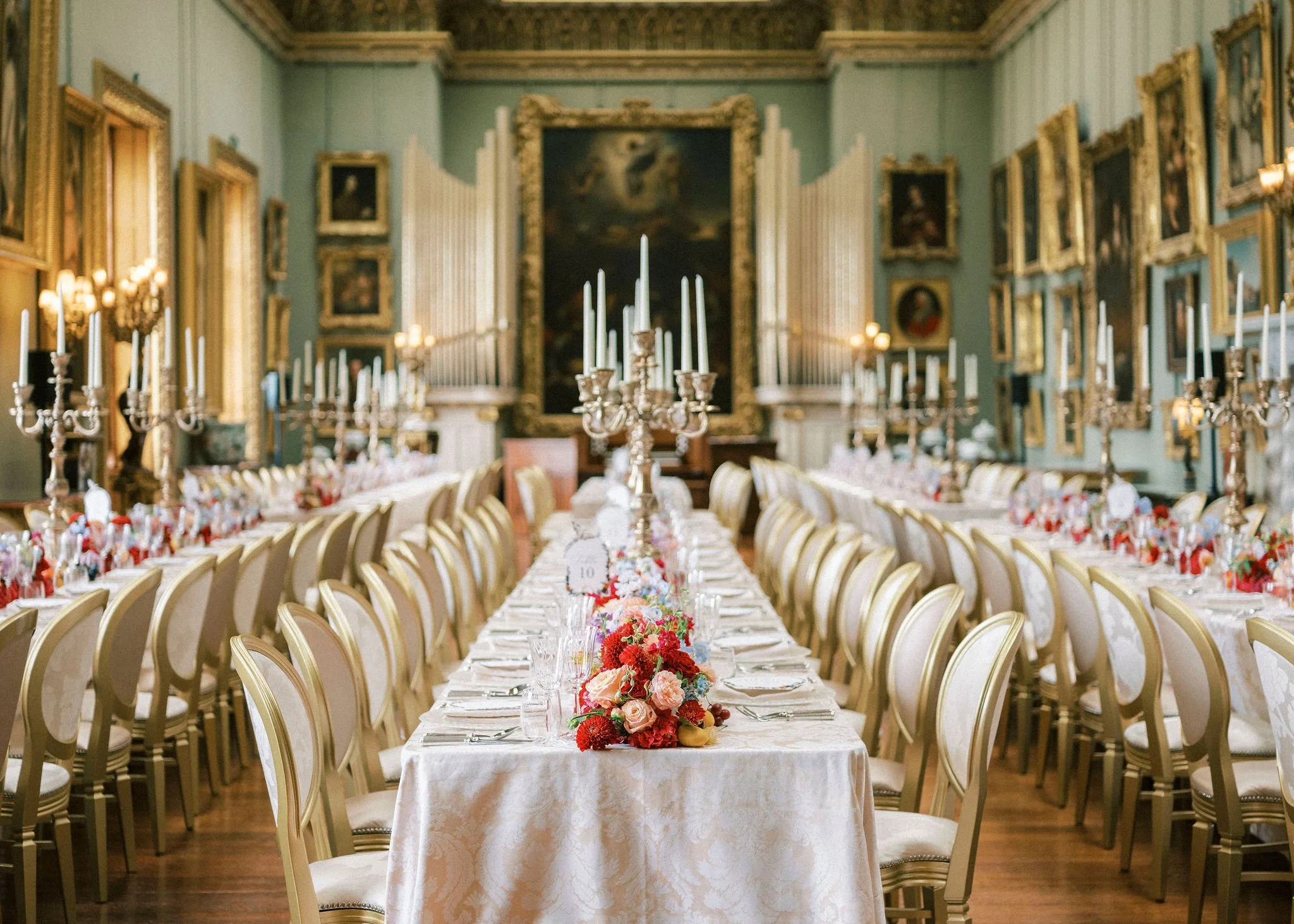 wedding breakfast on long tables in the picture gallery at Somerley house