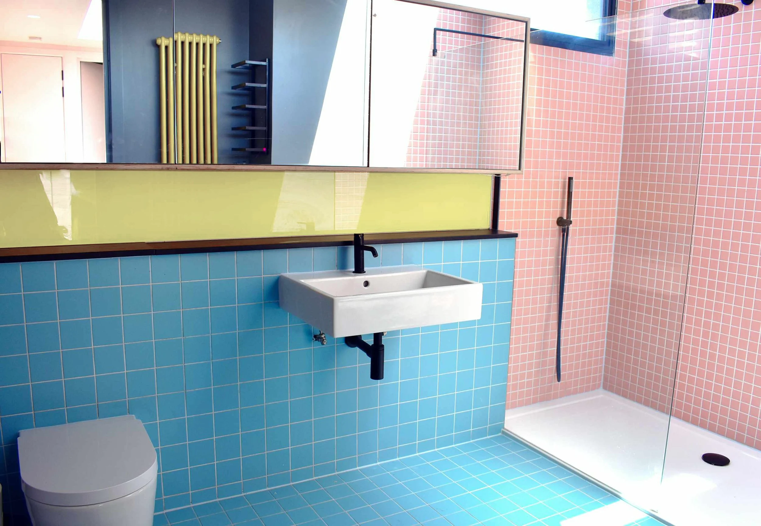 Colourful family bathroom created as part of a loft conversion in Hackney E5 with rooflight and walk-in shower.