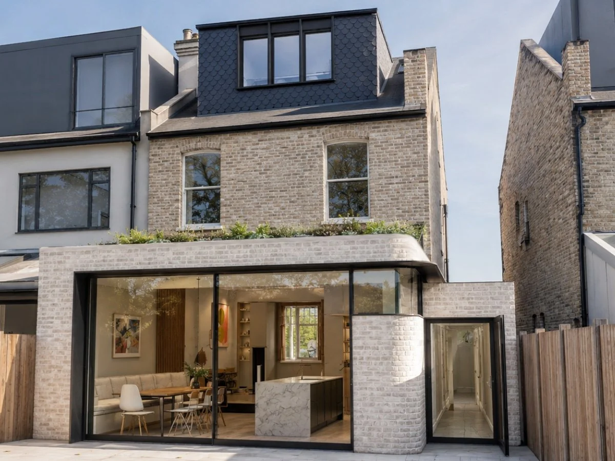 3D architectural rendering of a modern building extension with a rooftop garden, stairs, and patio, showing glass sliding doors and a brick exterior.