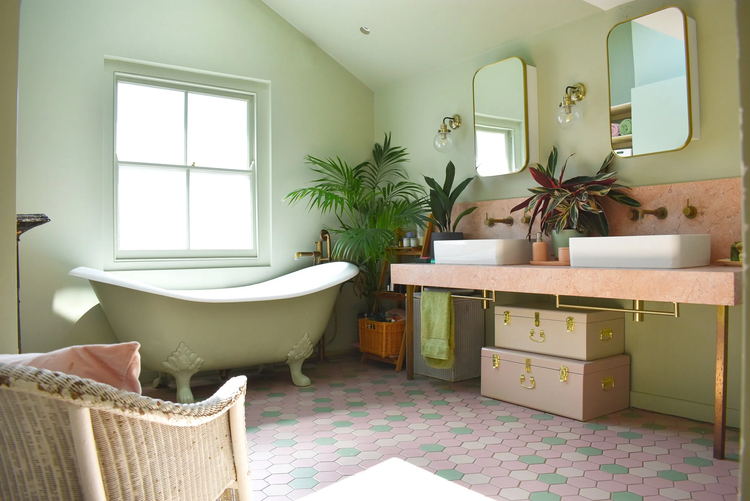 Principal bathroom renovation in Hackney E5 with a bespoke pink marble vanity, freestanding cast iron bath and restored Victorian fireplace.