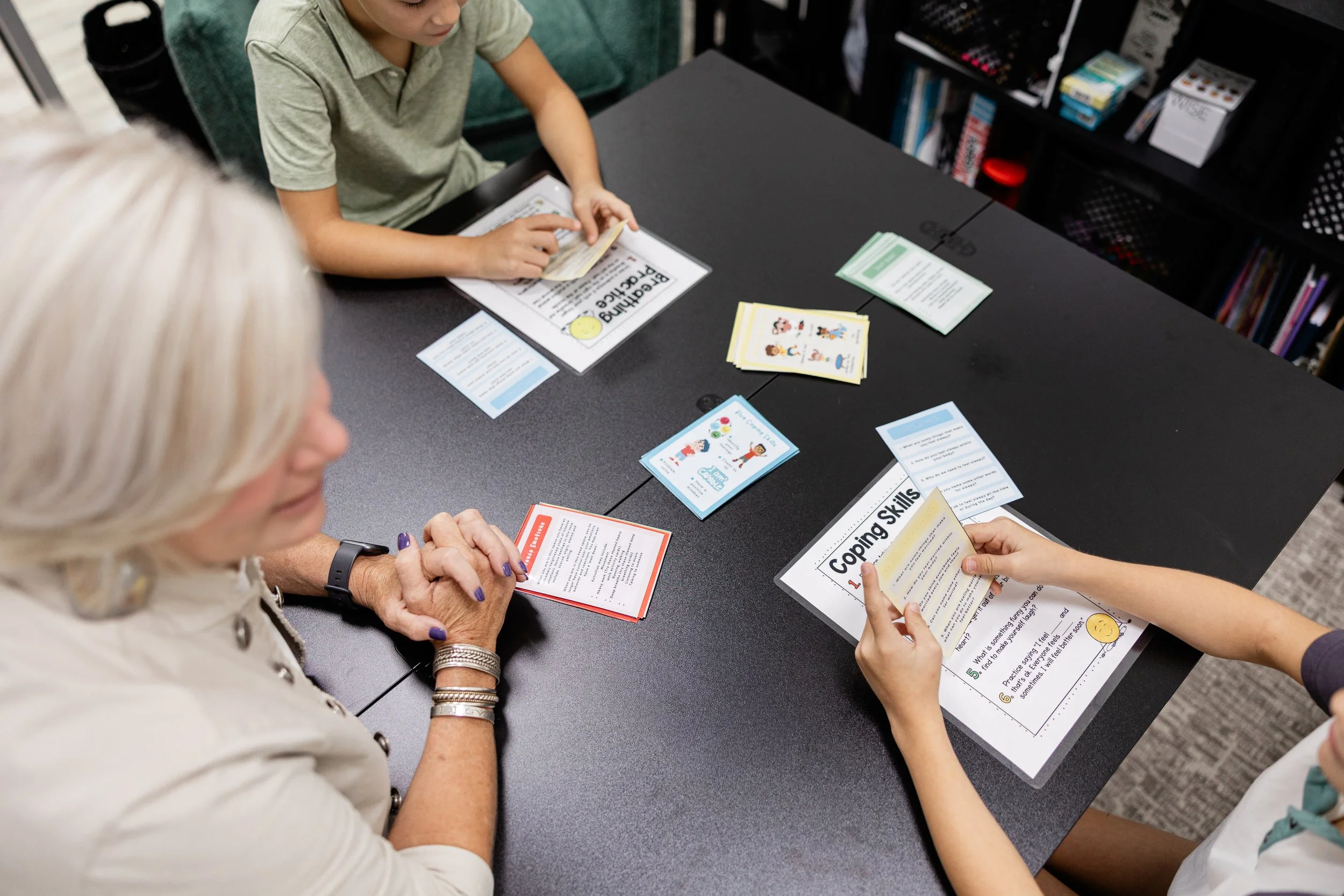 child practicing guided breathing and coping skills with instruction cards for emotion regulation