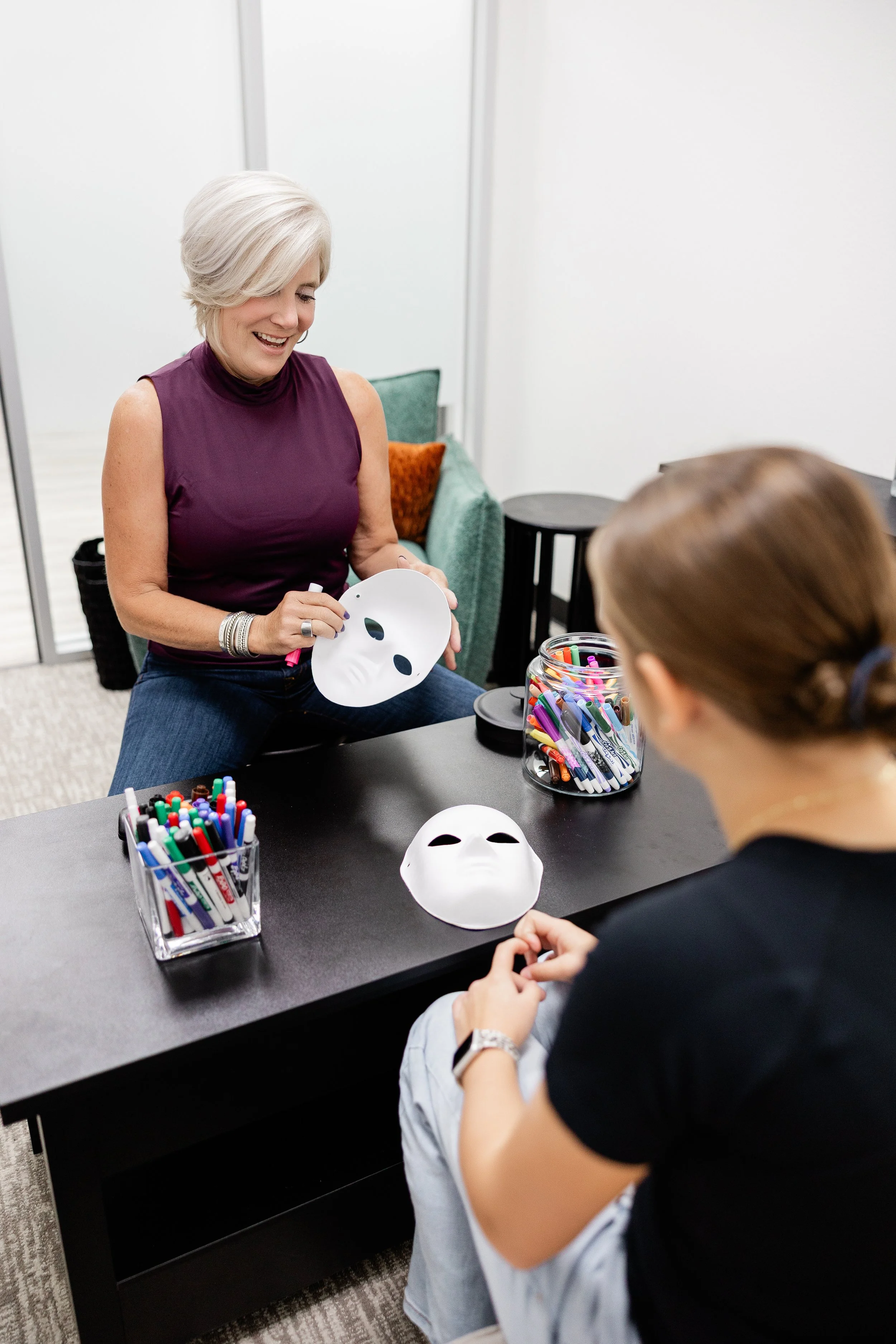 therapist guiding a teenager through a therapeutic art activity