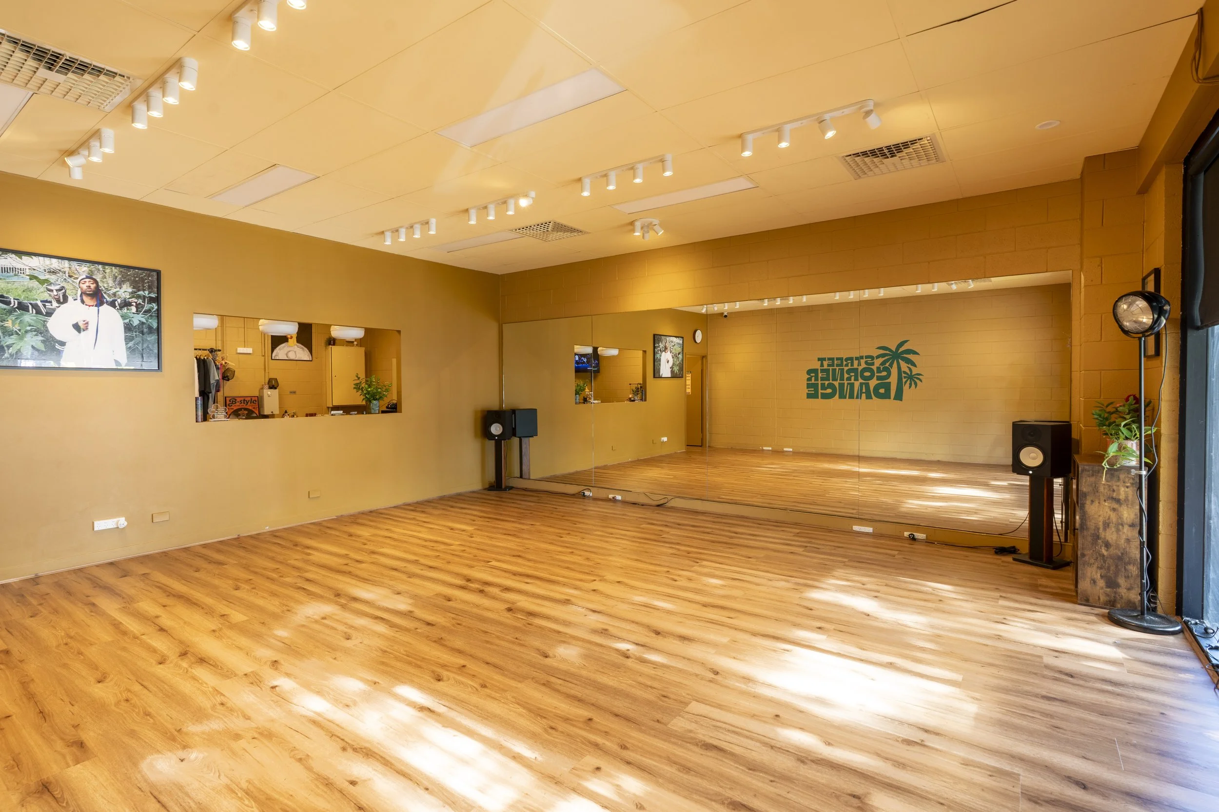 Street Corner dance studio in Perth with wooden floors, a large wall mirror, and a sign that reads 'Street Conference Dance' with a palm tree logo.