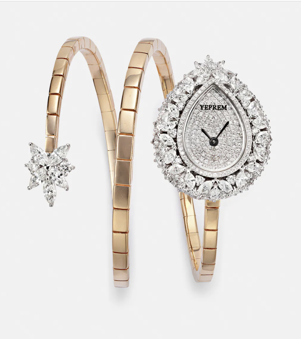 A luxurious wristwatch with a teardrop-shaped face, encrusted with diamonds, attached to a gold bracelet that extends into a star-shaped diamond embellishment.