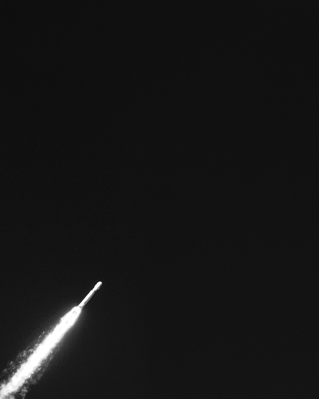 Rakete fliegt in den Himmel bei Nacht, Rauchtrail sichtbar