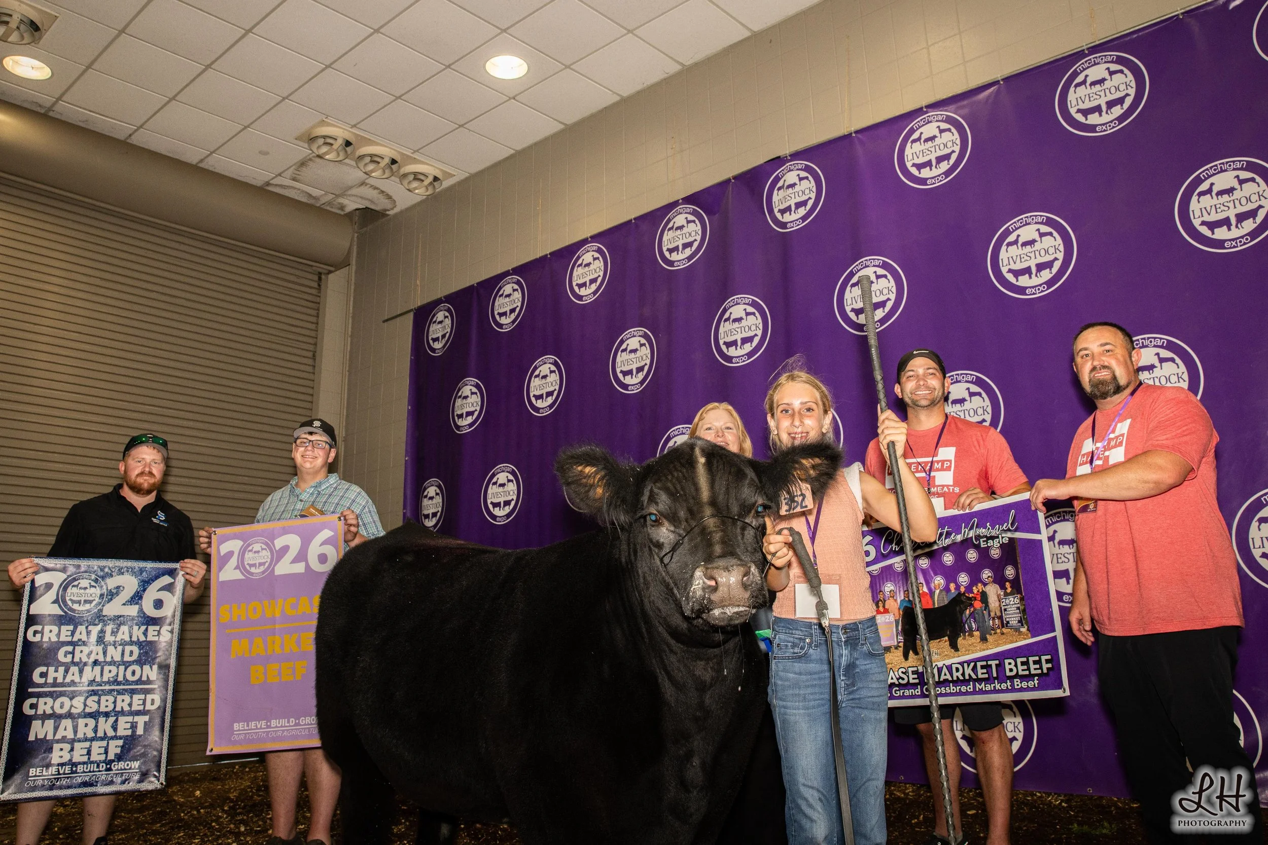 Charlotte Marvel at Sale-a-bration backdrop with Great Lakes Grand Crossbred Market Beef and Buyers