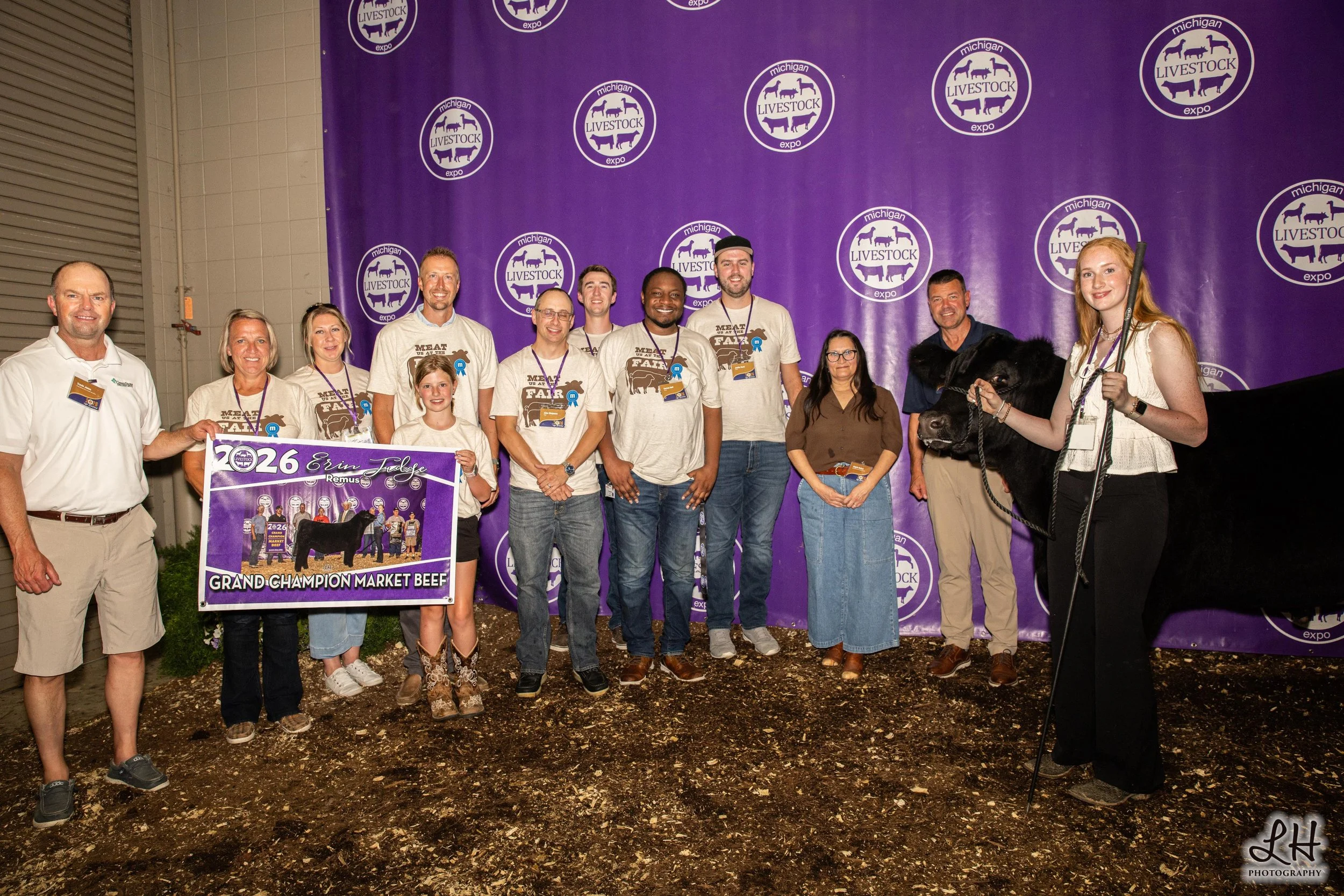 Backdrop photo of Erin Judge with her Grand Champion Market Beef animal and her buyers at the Sale-a-Bration.