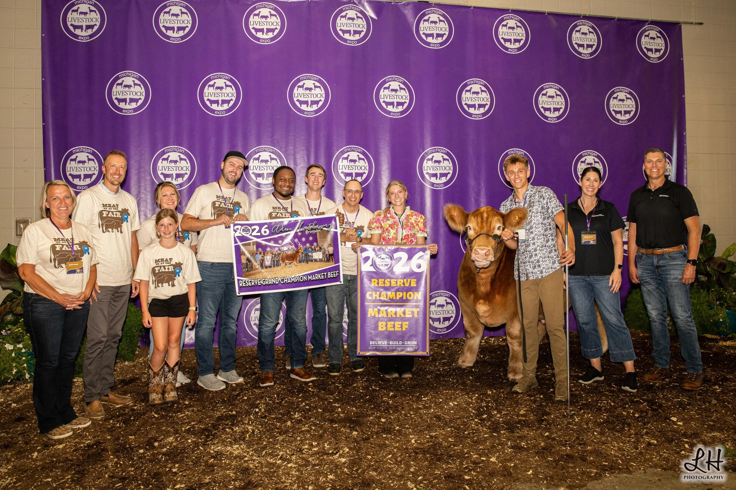 Aden Hathaway at the backdrop during the Sale-a-Bration with his Reserve Grand Champion Market Beef and buyers.
