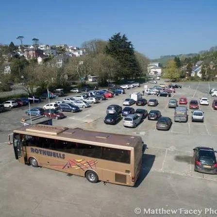 This is Willow Carpark in Mevagissey, the main car park, it currently show a photo that includes lots of parked cars and a big gold coach.