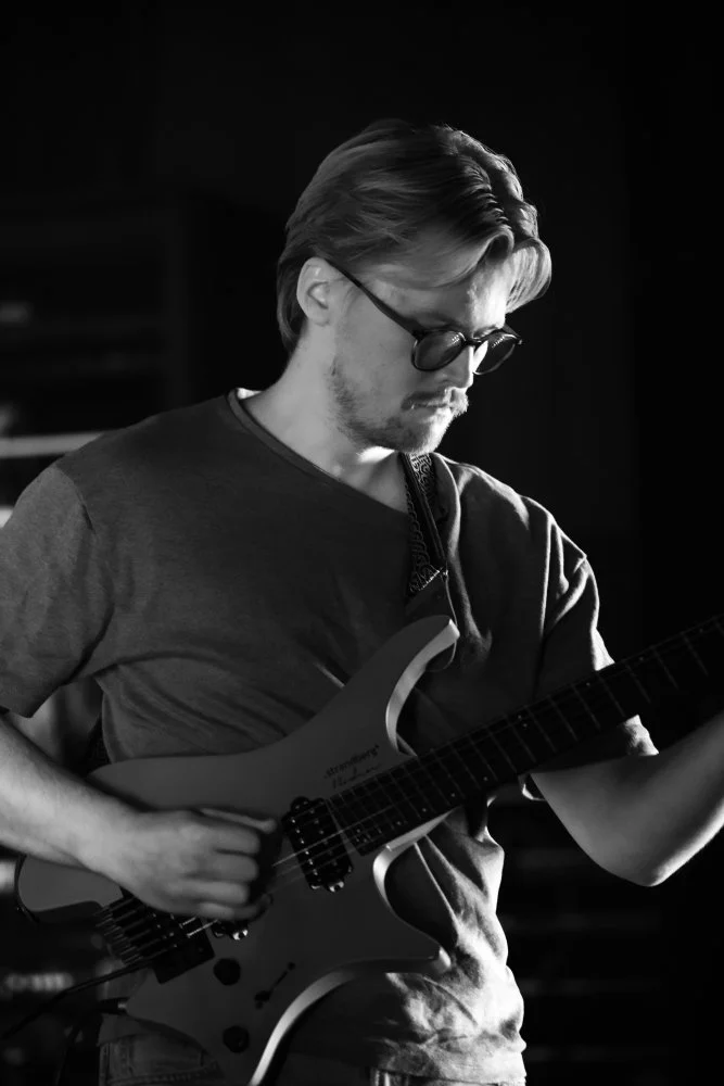 Svart hvitt bilde av en gitarist som spiller elektrisk gitar.