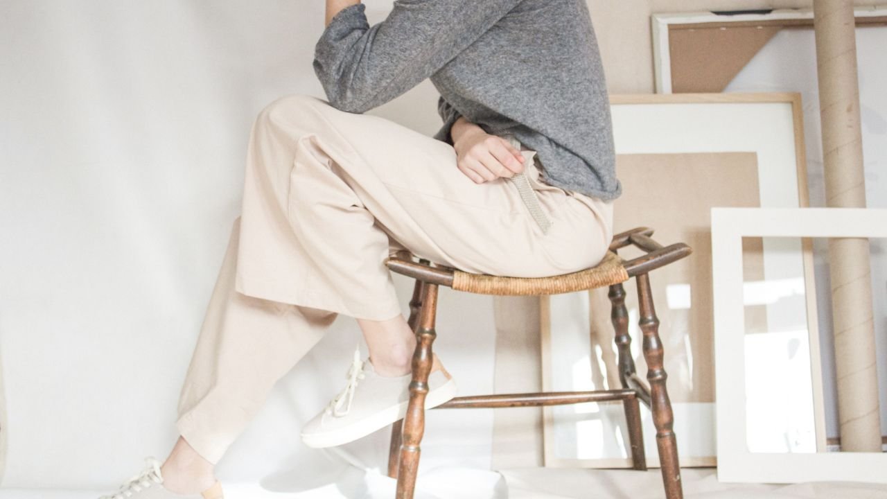 Midlife woman sitting on a chair in quiet self-reflection and calm mindset reset