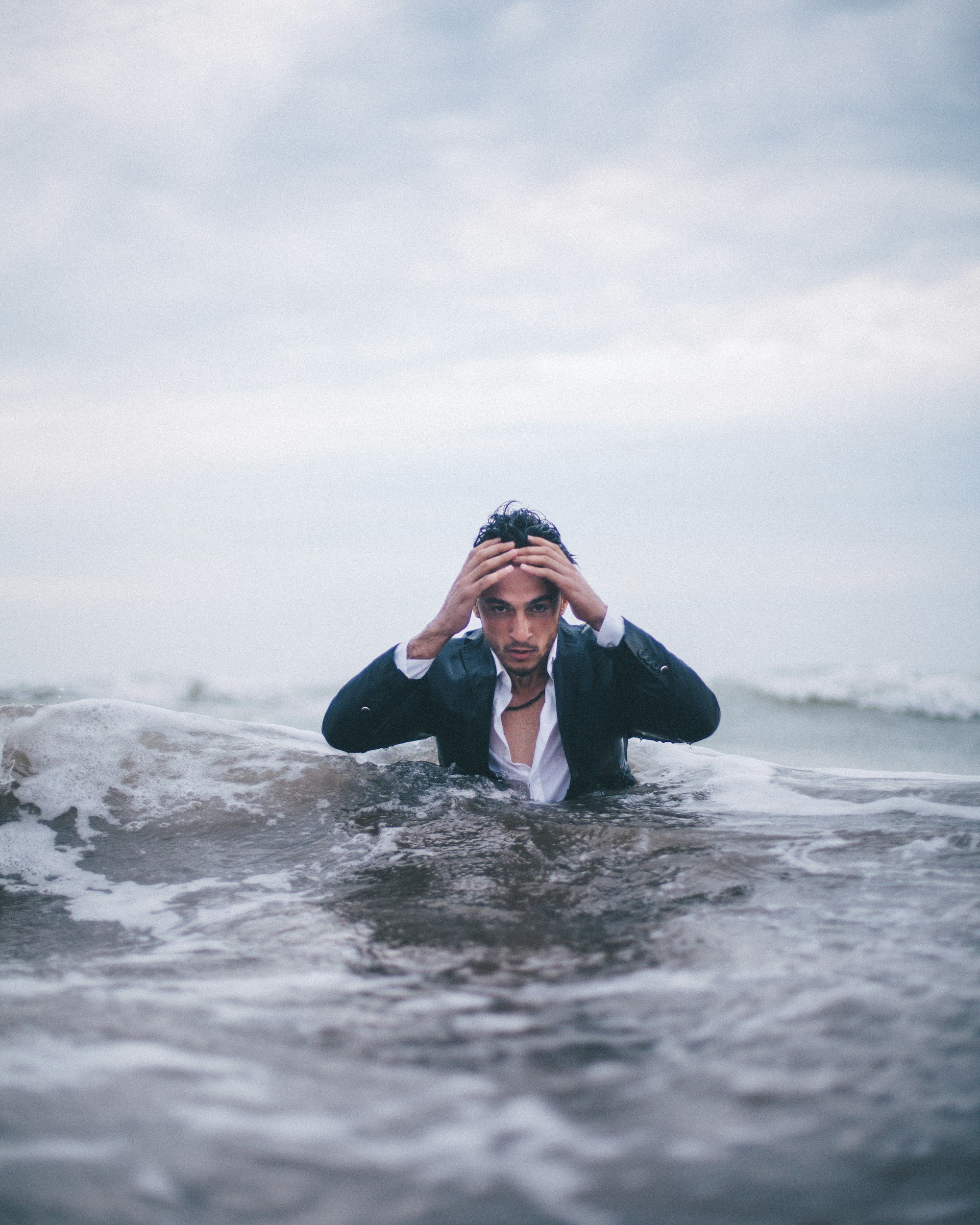 man in ocean stressed to symbolize overwhelm and ruminating thoughts