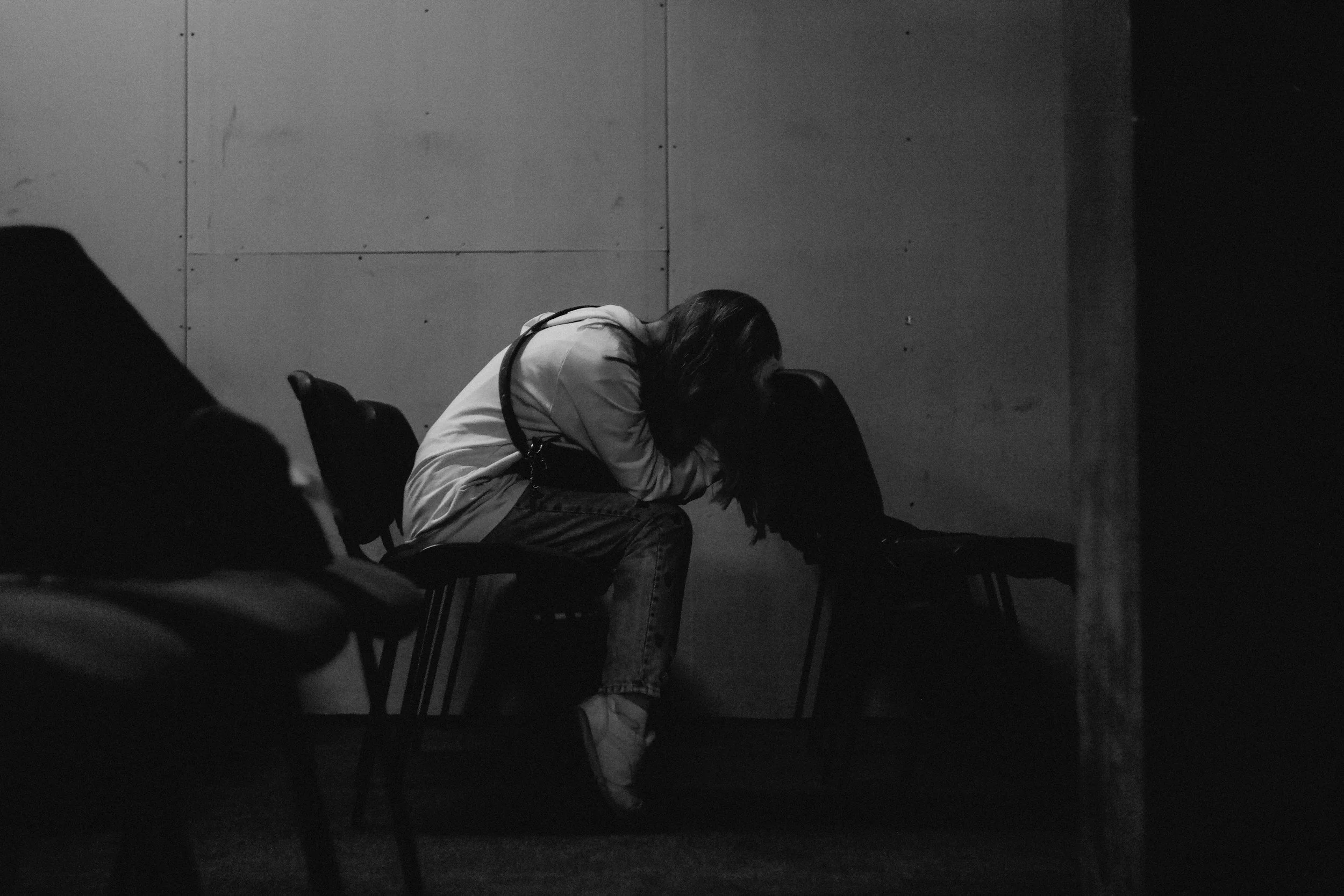 woman sitting in classroom with head down representing grief