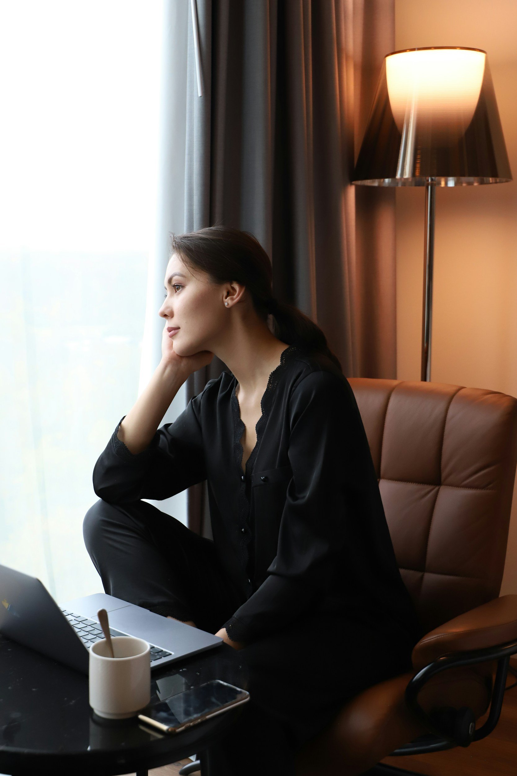 woman executive looking out the window in a leather chair