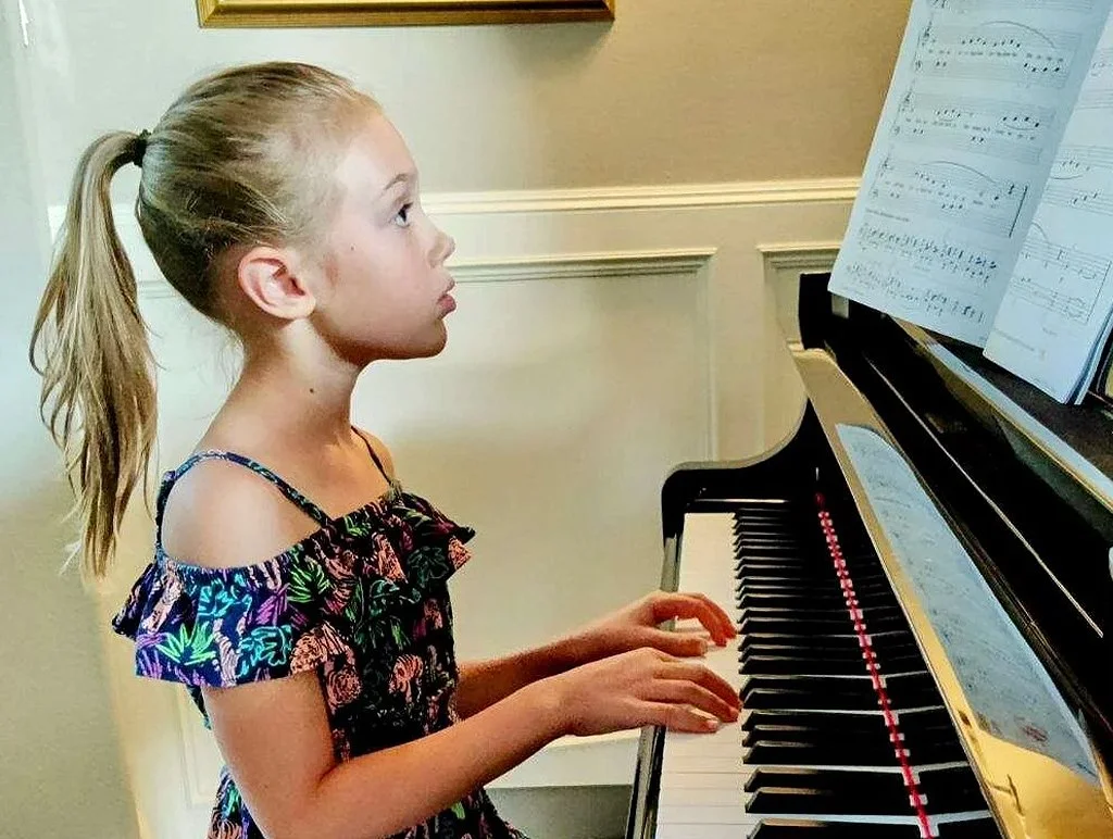 Image of young female student playing piano