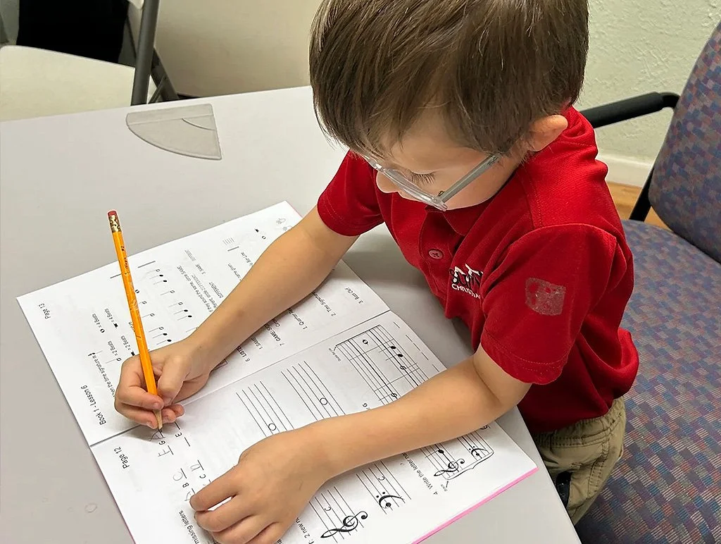 Image of young male student working on music workbook