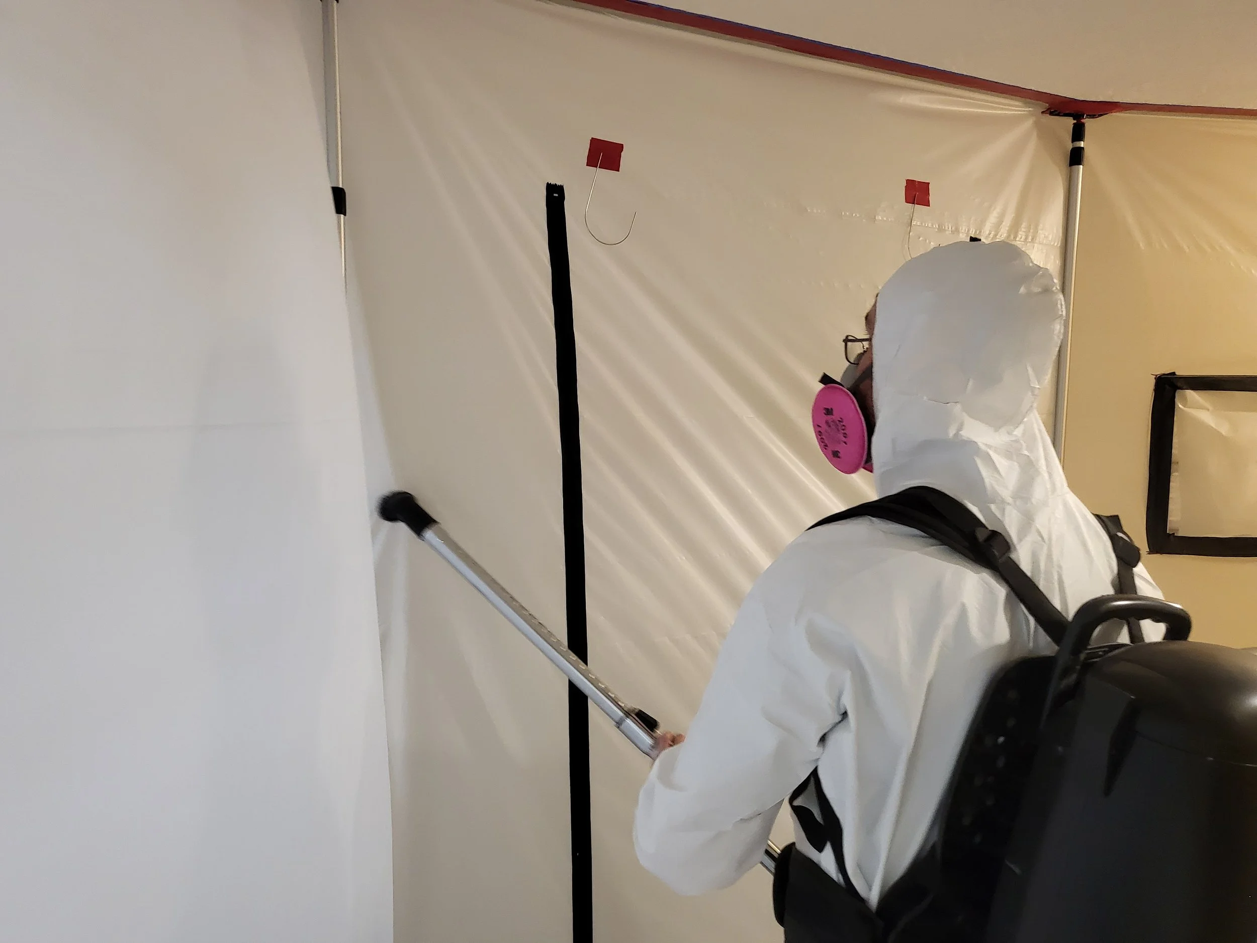 Restoration technician establishing containment for controlled cleanup