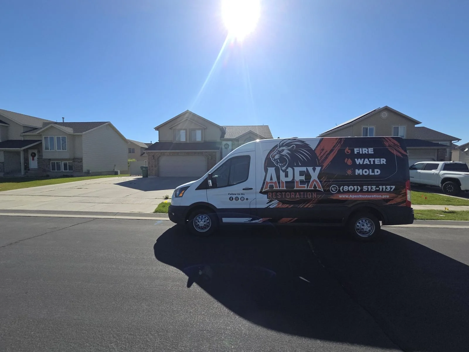 Apex Restoration service van parked in front of a Utah home.