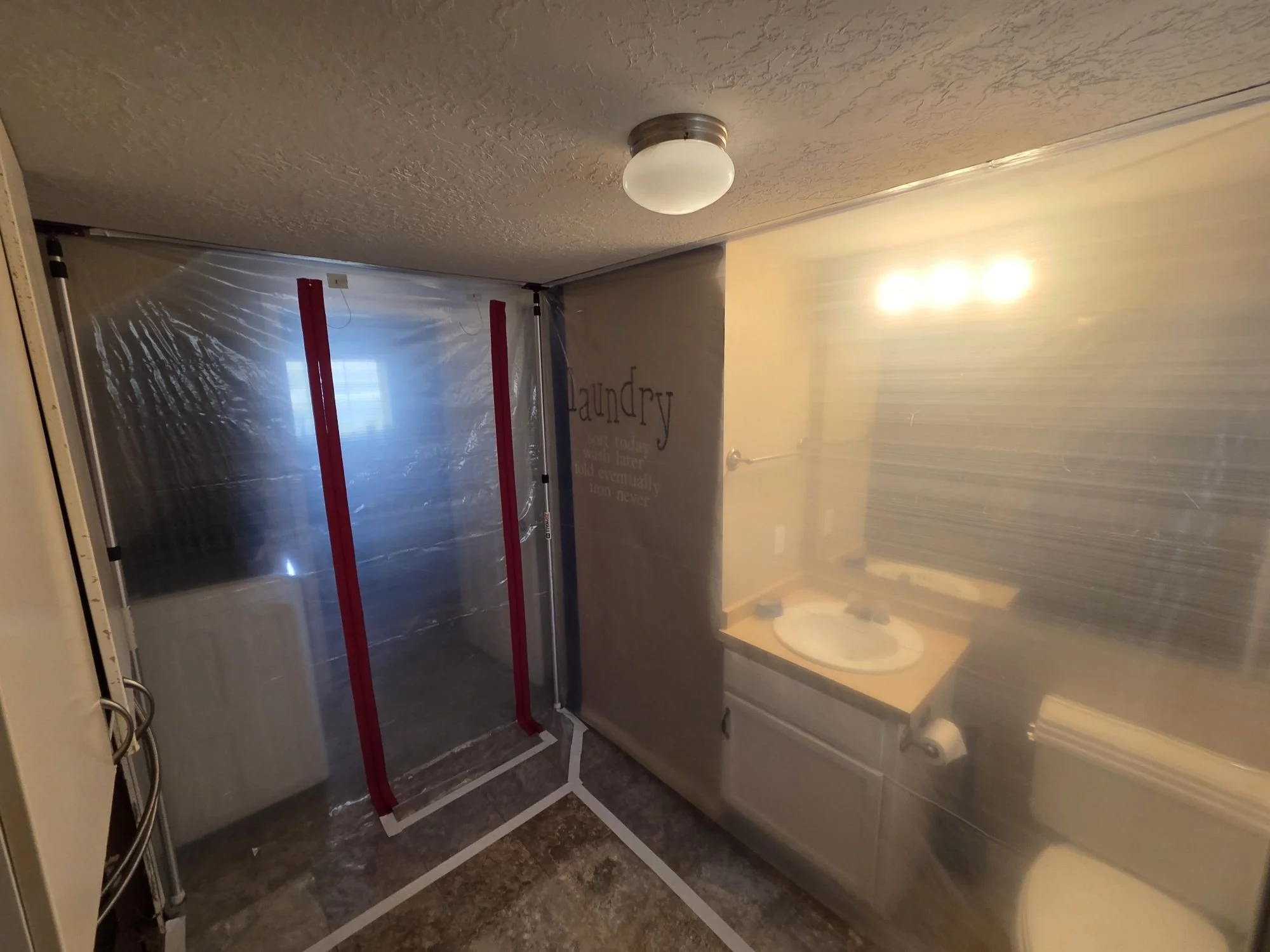 Plastic containment installed in a bathroom during mold remediation.