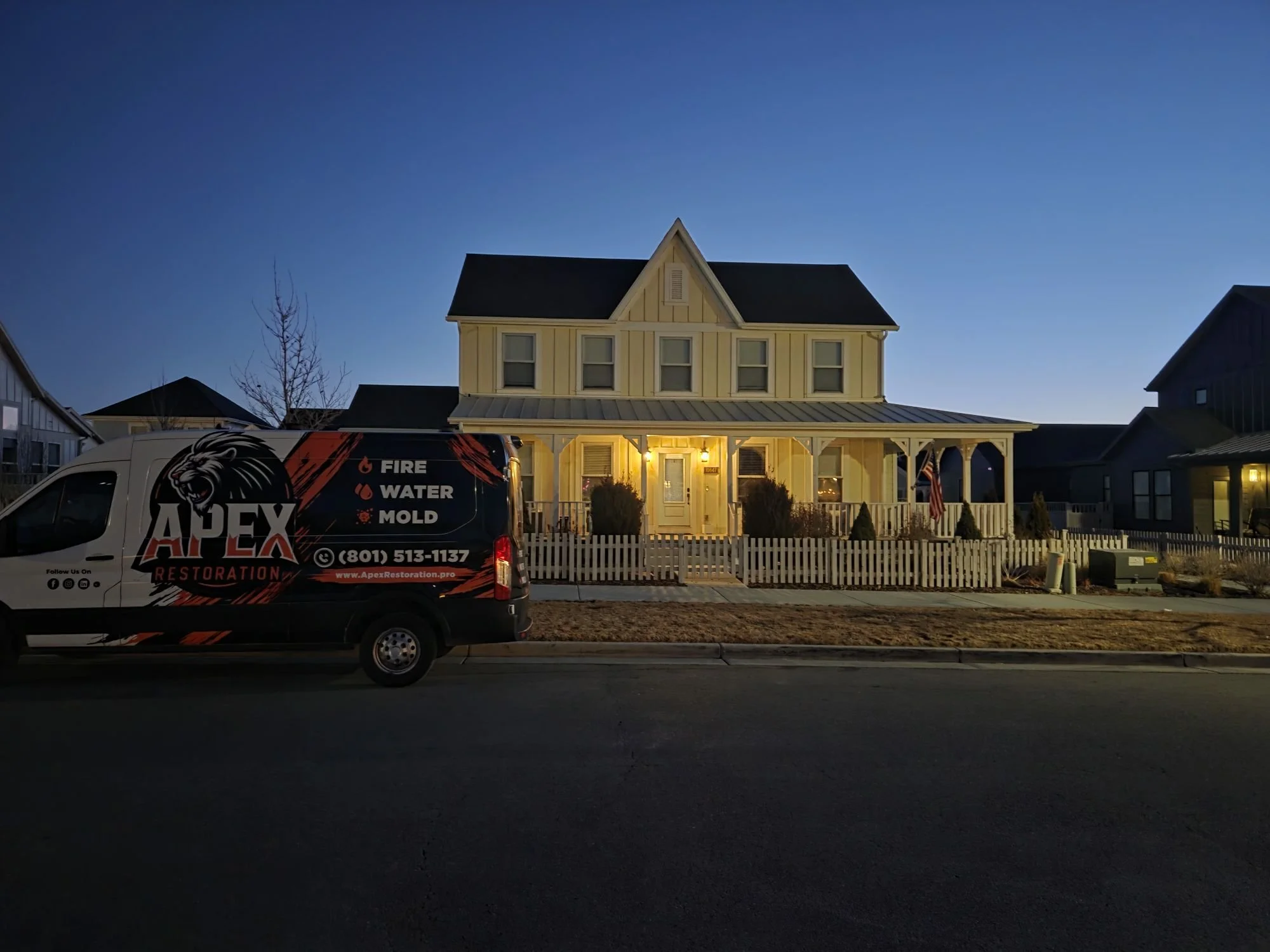 Apex Restoration service van outside a Utah home at dusk