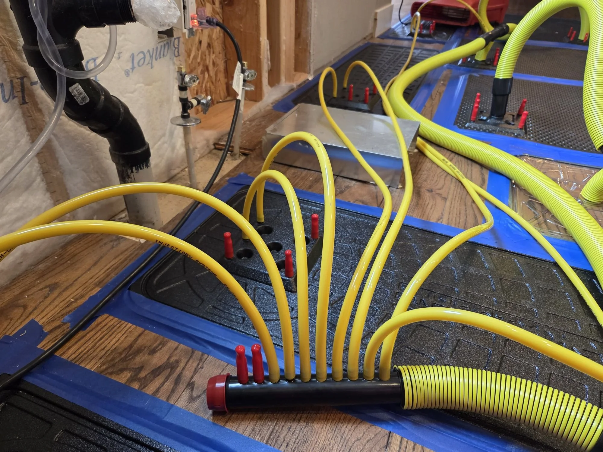 Injectidry floor-drying system drying water-damaged hardwood flooring.
