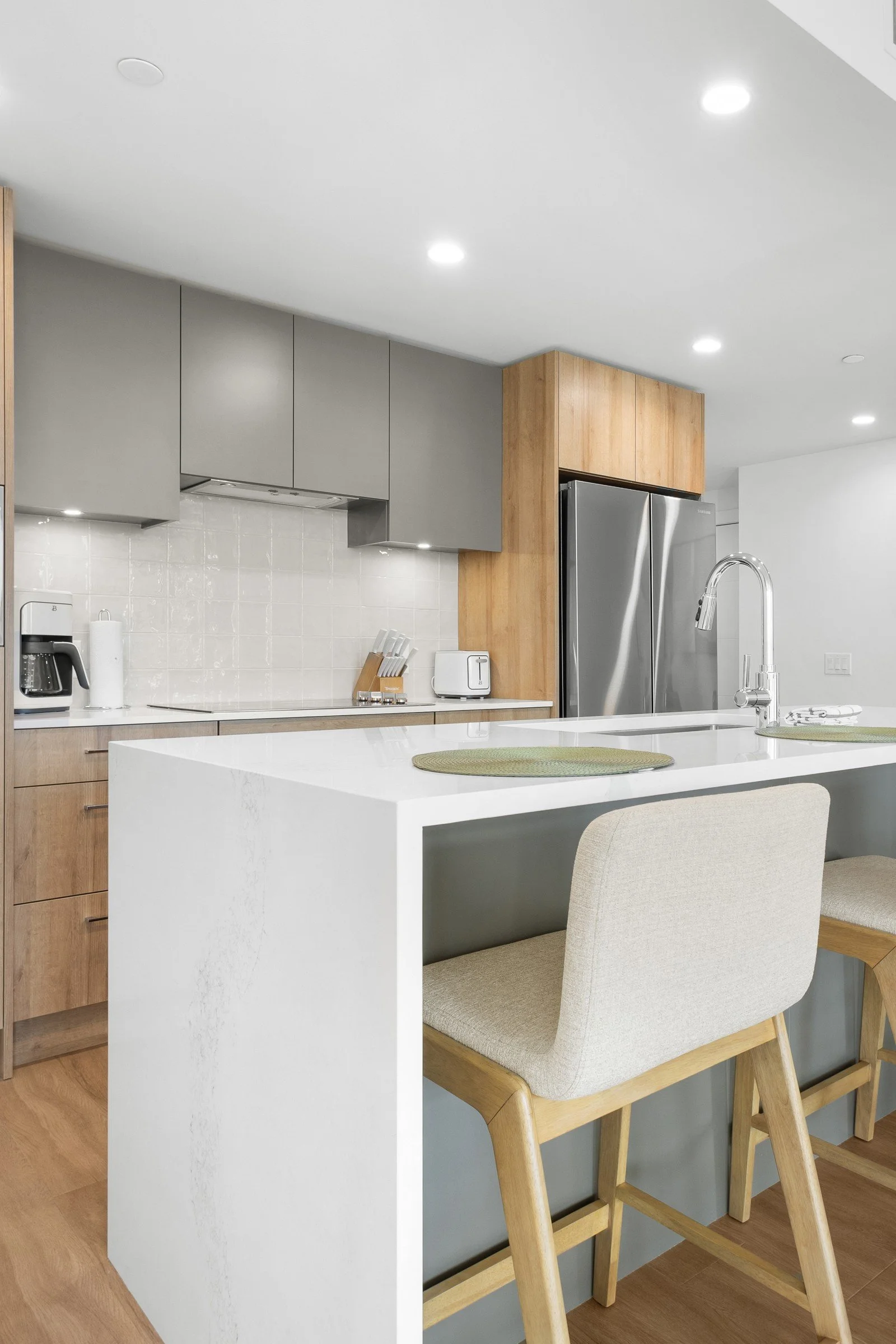 Condo kitchen with white island and bar stools