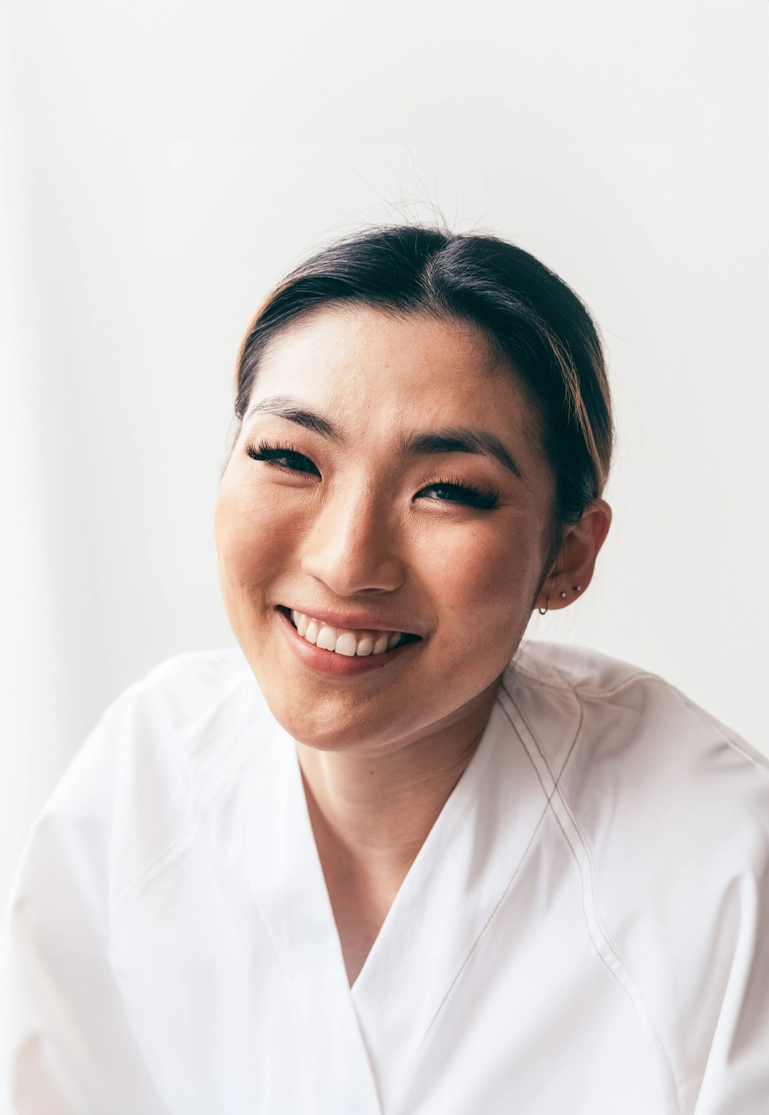 Smiling woman in a white shirt against a light background
